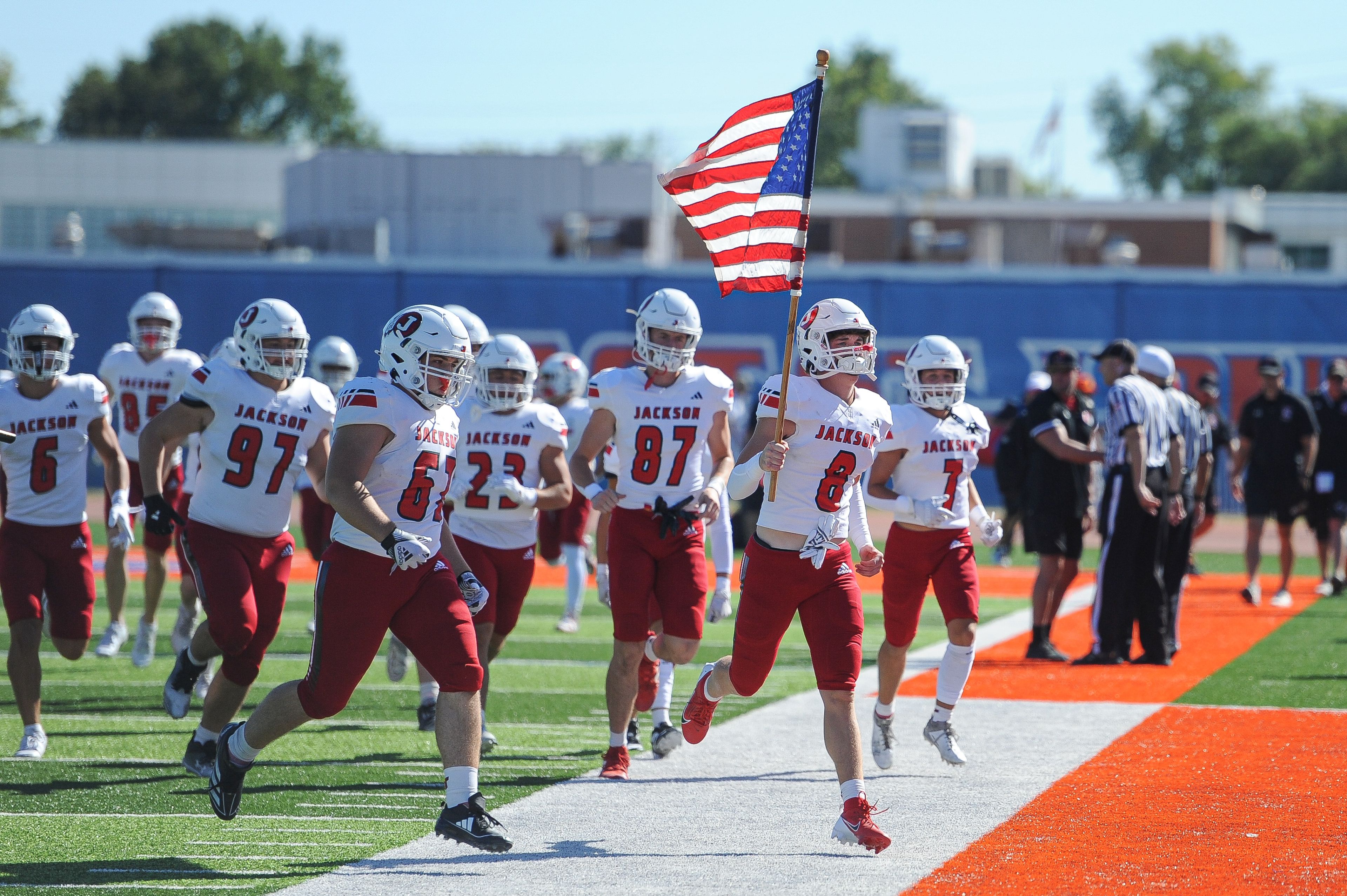 Jackson's Tyson Ford (right-center) leads the team out with the American flag during a Saturday, September 7, 2024 game between the Jackson Indians and the Cahokia Comanches at East St. Louis Senior High School in East St. Louis, Ill. Jackson defeated Cahokia, 49-26.