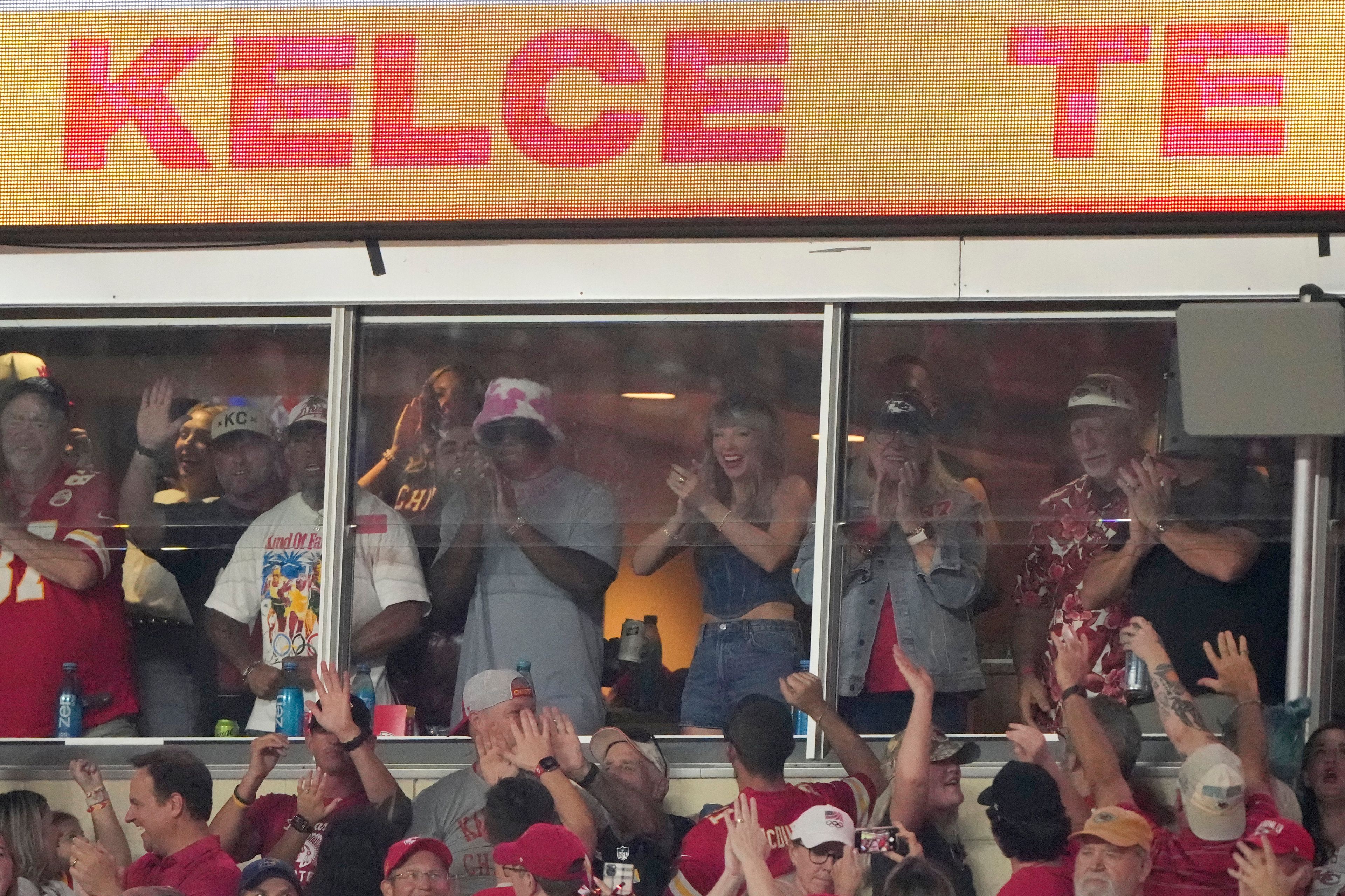 Taylor Swift applauds as she watches from a suite during the first half of an NFL football game between the Kansas City Chiefs and the Baltimore Ravens Thursday, Sept. 5, 2024, in Kansas City, Mo. (AP Photo/Charlie Riedel)