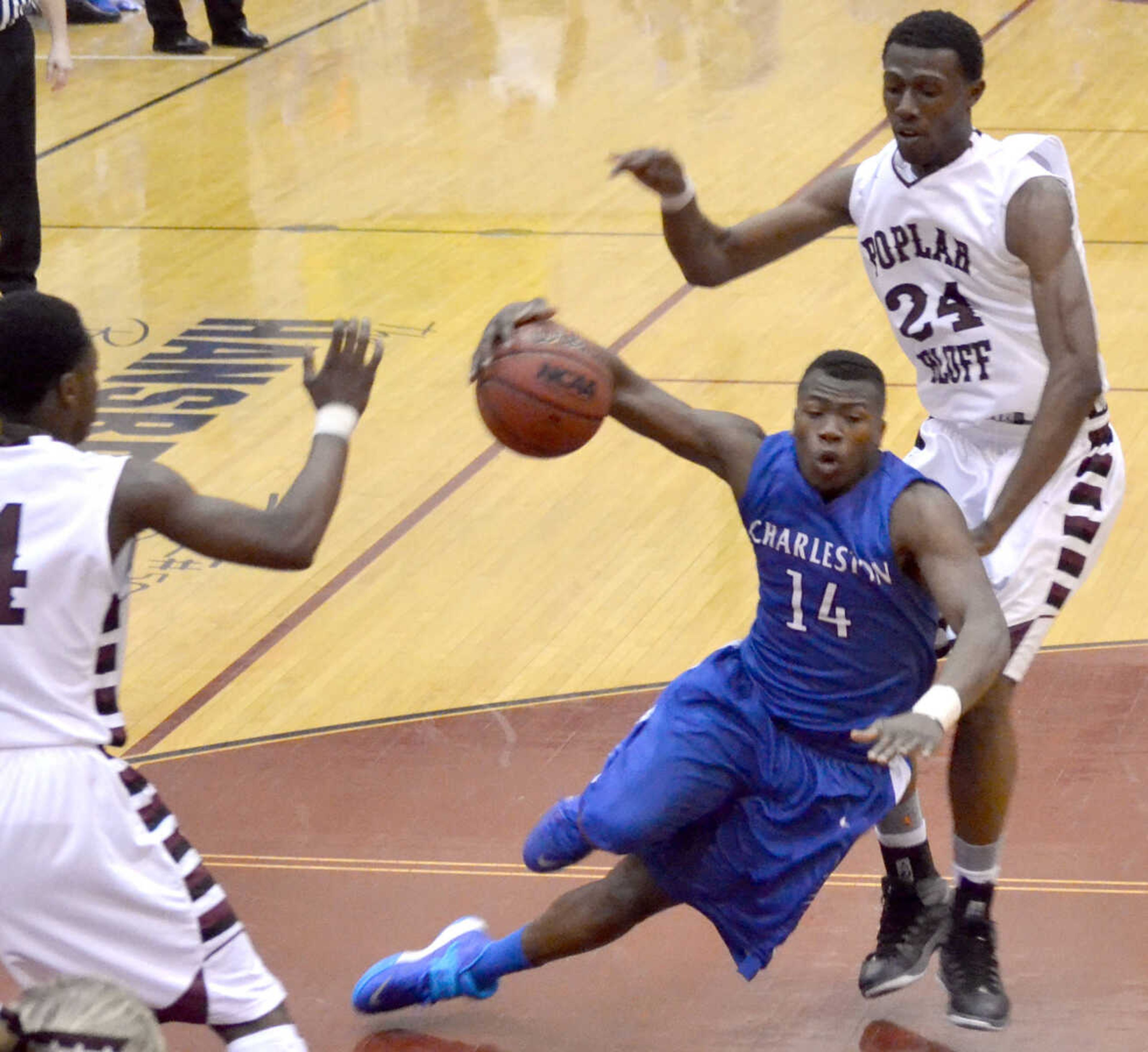 Charleston's Robert Bogan (14) loses his footing in front of Poplar Bluff's Stacy Gibson (24) Friday at Poplar Bluff High School. (Brent Shipman Photo)