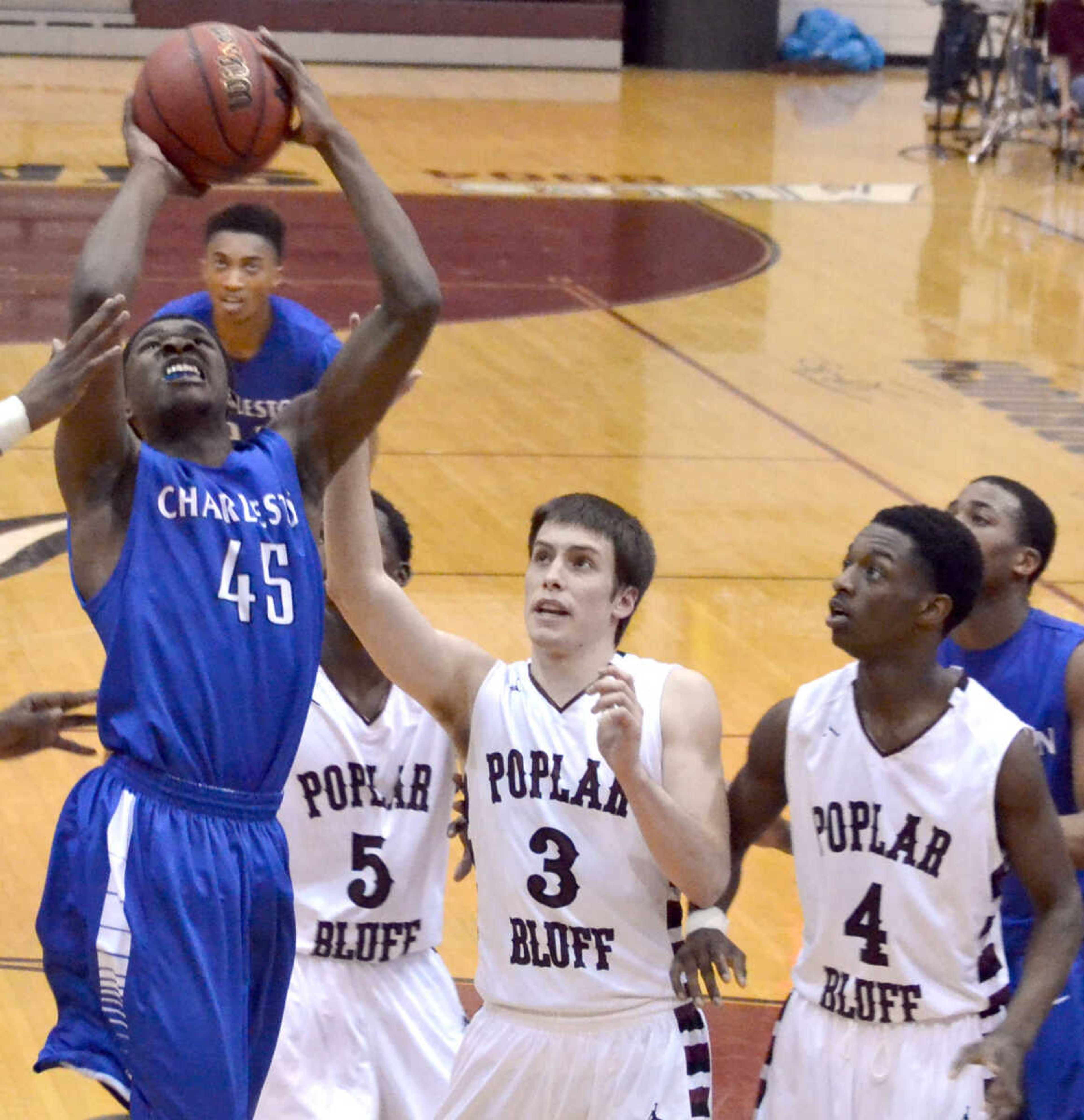 Charleston's Timontrail Horton (45) attempts a shot in front of Poplar Bluff's Joseph Eyler (3) and Malik Metcalf (4) Friday at Poplar Bluff High School. (Brent Shipman Photo)