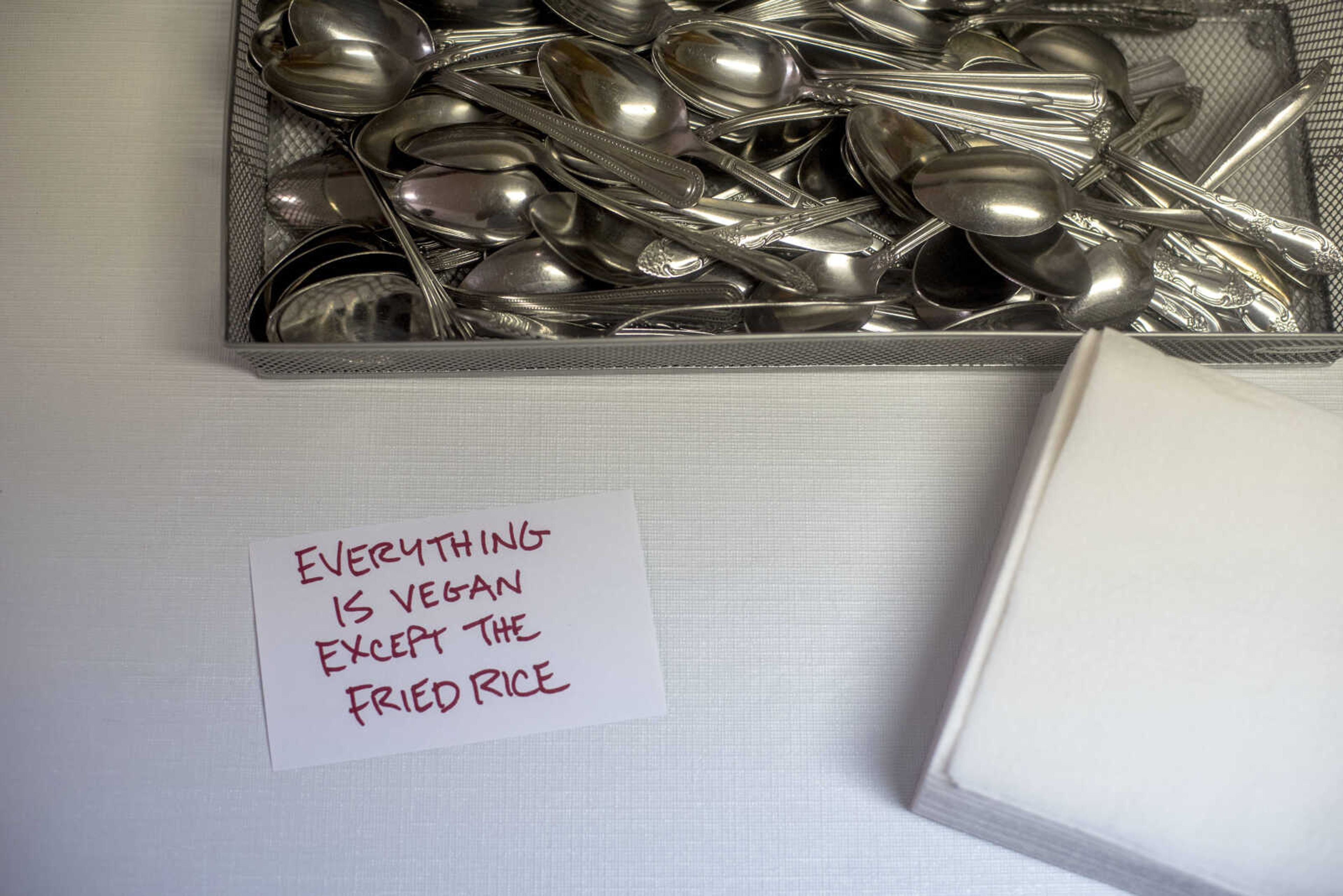 Cutlery is seen near a disclaimer at the start of a refugee-style food buffet Wednesday, June 19, 2019, at Cape Girardeau in Abbey Road Christian Church.  
