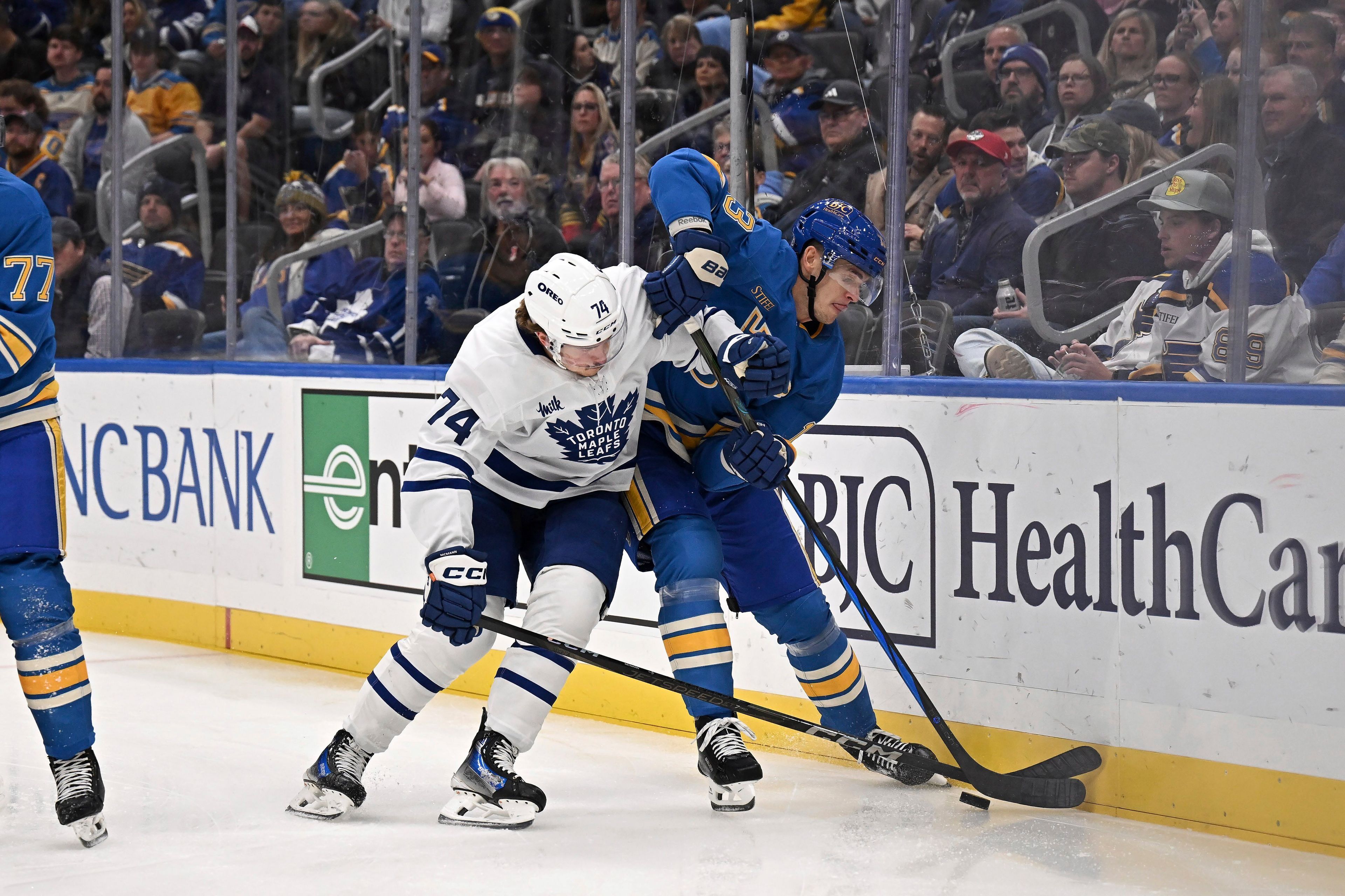 St. Louis Blues' Alexey Toropchenko (13), right, and Toronto Maple Leafs' Bobby McMann (74) battle for the puck during the first period of an NHL hockey game Saturday, Nov. 2, 2024, in St. Louis. (AP Photo/Connor Hamilton)