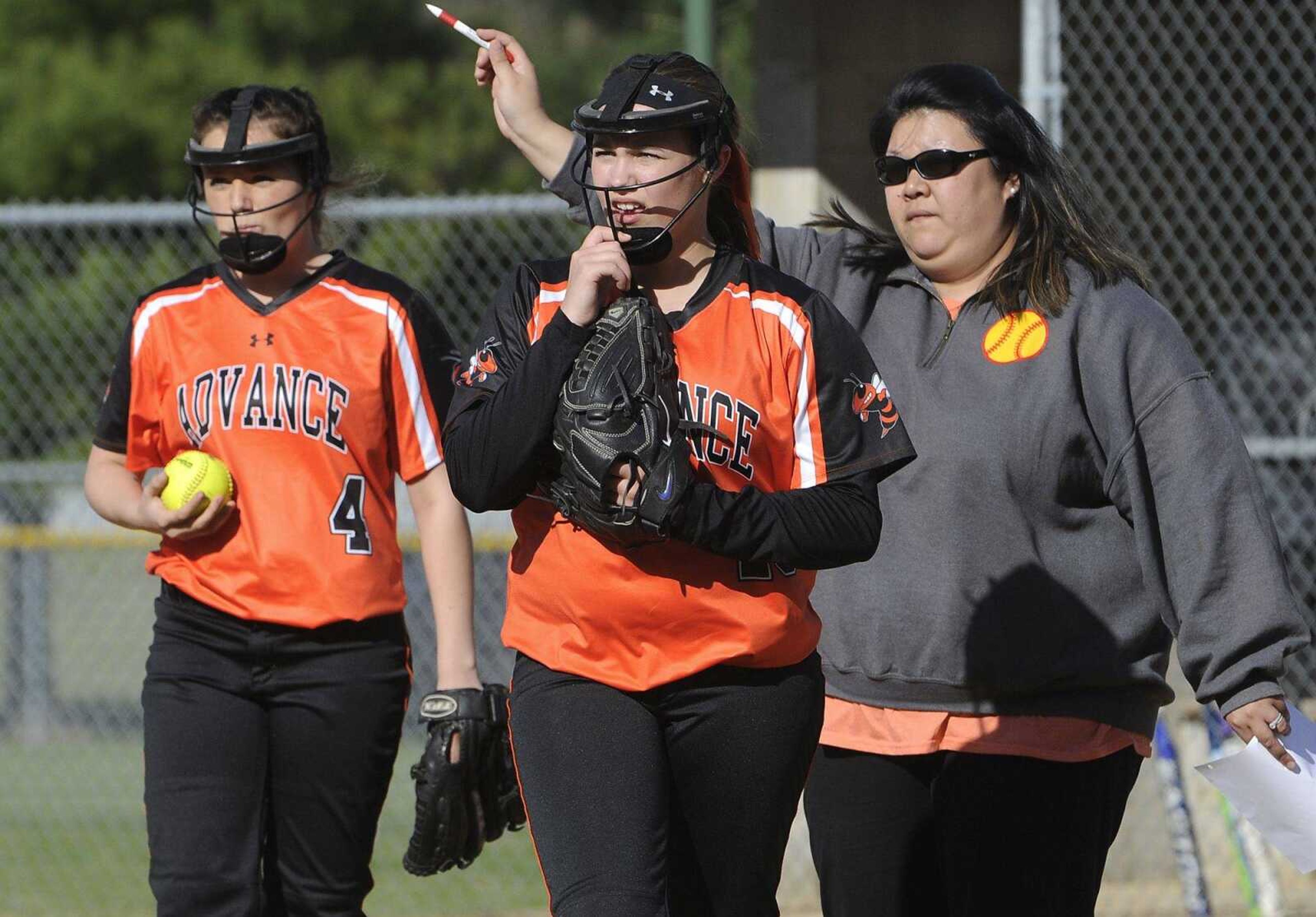 Advance starter Cooper Simpson, center, is reassigned to third base by coach Sara Cundiff as reliever Alli Johnson takes the mound during the second inning Friday, April 8, 2016 in Oran, Missouri.