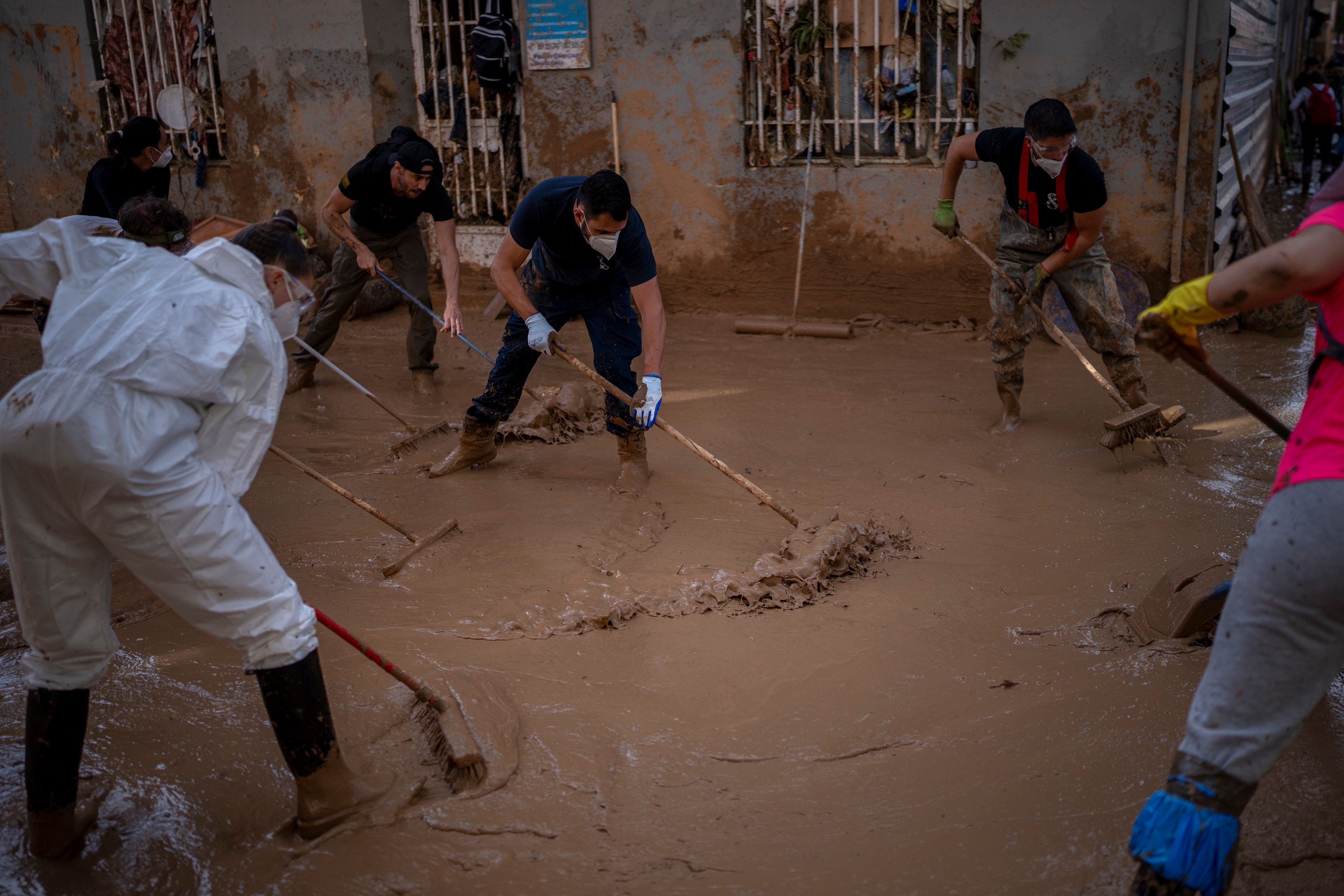 Members of the army, police and volunteers clean the mud after the floods, in Masanasa, Valencia, Spain, Thursday, Nov. 7, 2024. (AP Photo/Emilio Morenatti)