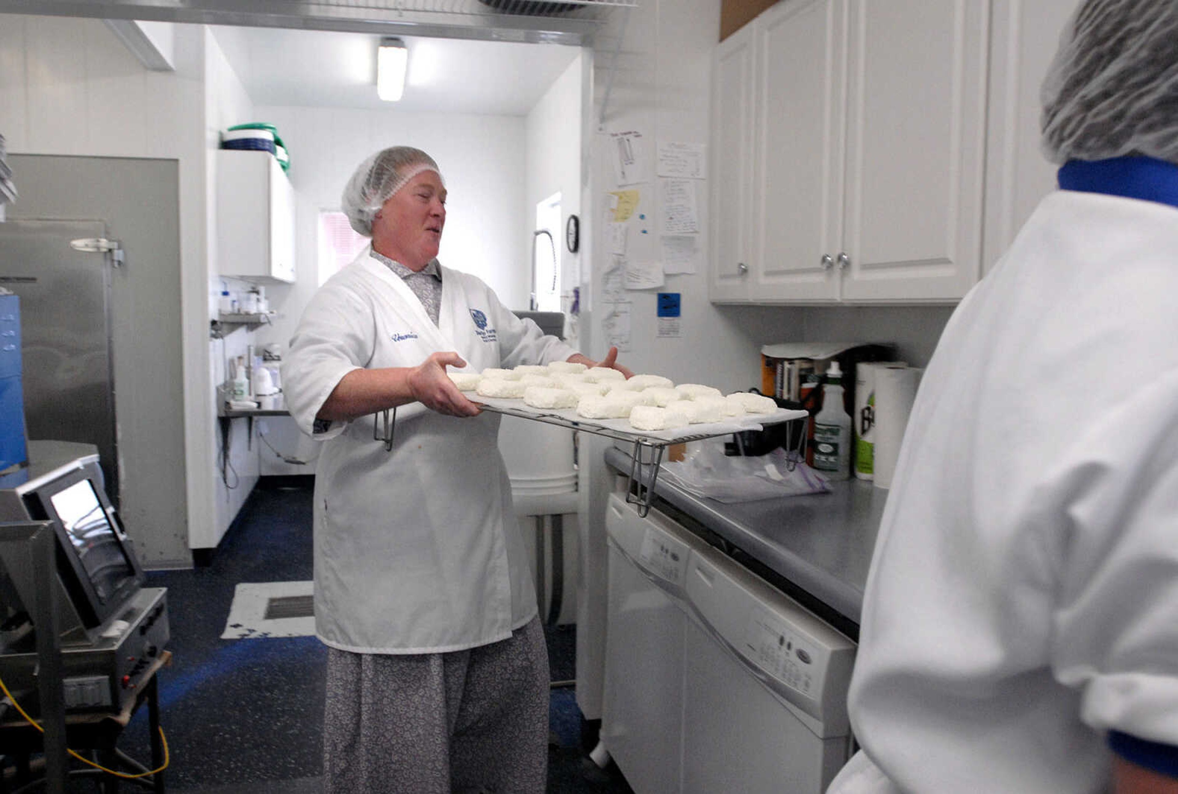 LAURA SIMON ~ lsimon@semissourian.com
Veronica Baetje brings out a tray of heart shaped Coeur de la Creme, pure artisan goat cheese to be seasoned Wednesday, Dec. 14, 2011 at Baetje Farms in Bloomsdale, Mo. Baetje seasoned the goat cheese using organic fresh ground pepper just before packaging.