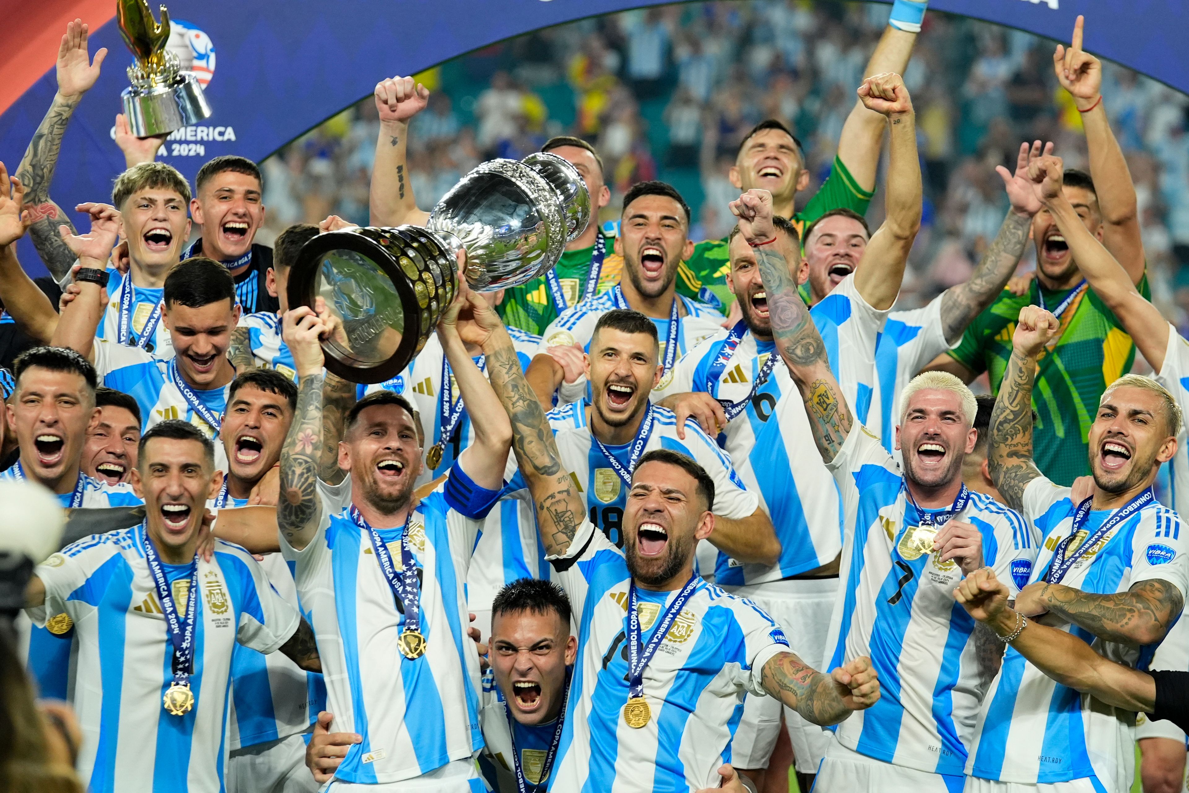 FILE - Argentina's Lionel Messi, holding the Copa America trophy, celebrates with teammates their victory over Colombia in the Copa America final soccer match in Miami Gardens, Fla., July 15, 2024. (AP Photo/Rebecca Blackwell, File)