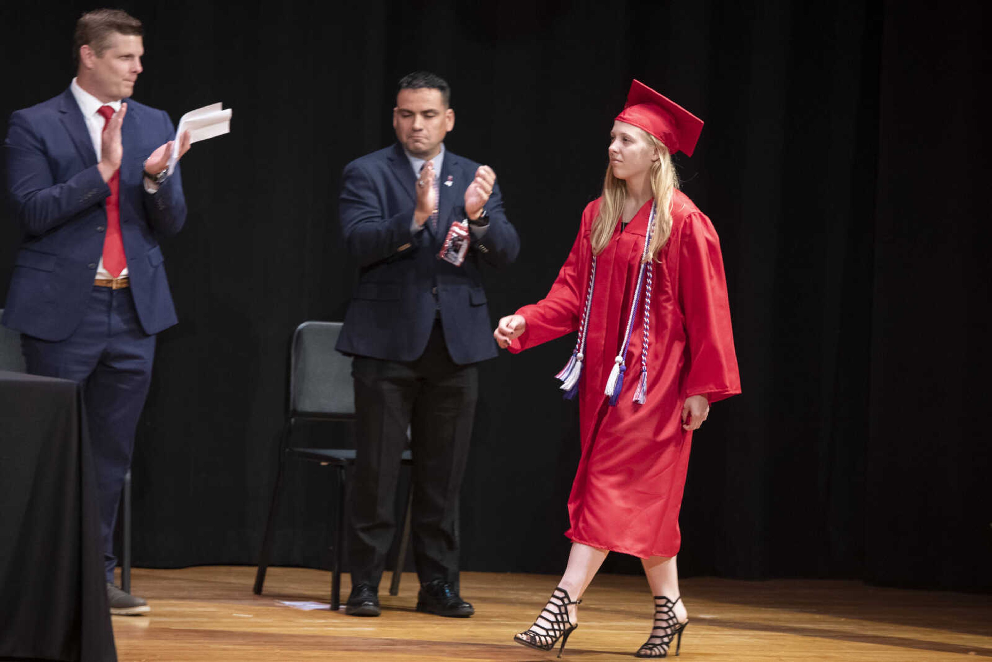 Jackson High School graduate Erin Taylor Huff walks across the stage near commencement speaker William Lewis (middle) and principal Seth Harrell (left) during an in-person military graduation ceremony Friday, May 22, 2020, at Jackson High School.