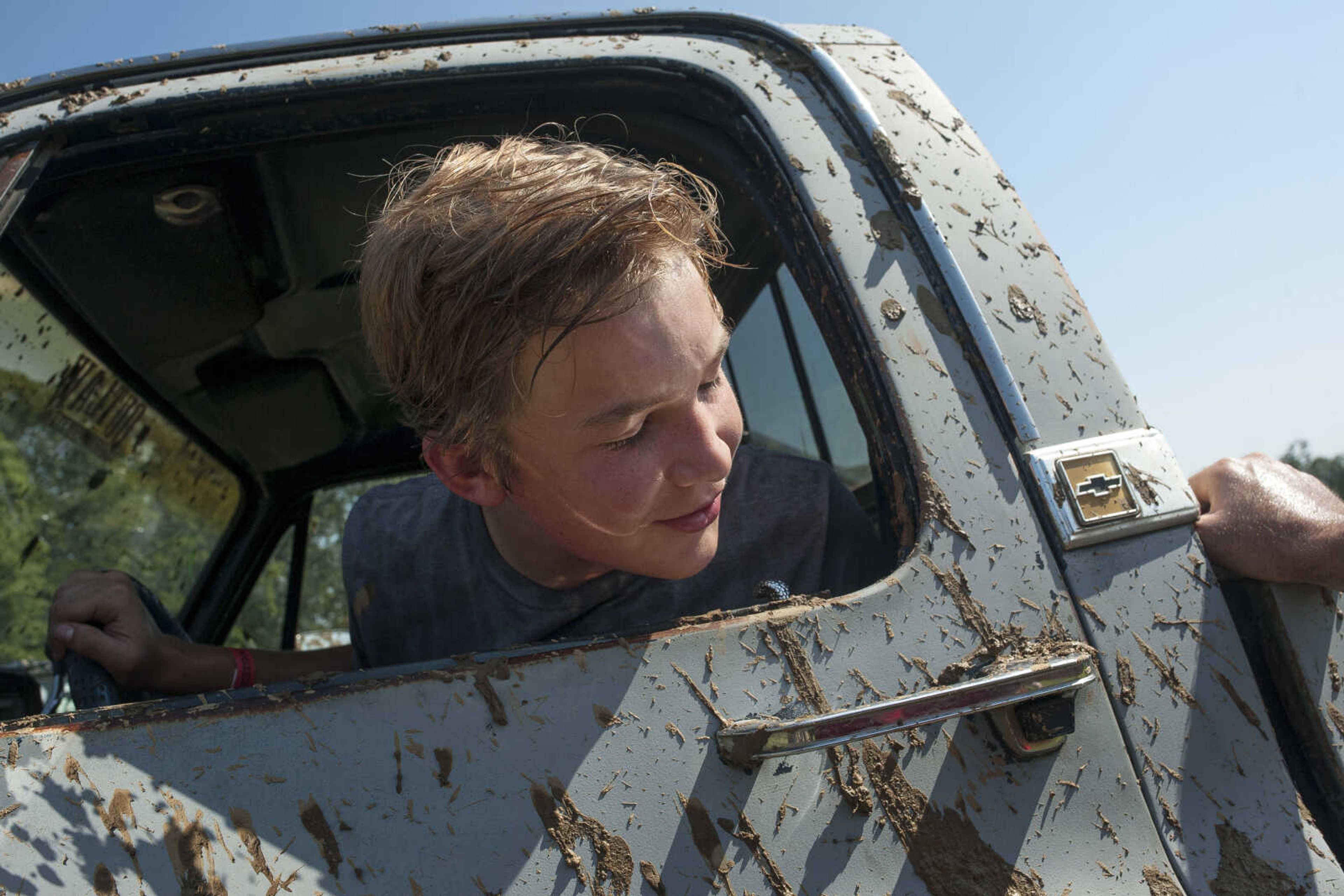 Matthew Jenkins looks at the mud on his '85 Chevy Scottsdale at the annual mud races during Benton Neighbor Days  Saturday, Aug. 31, 2019 in Benton.