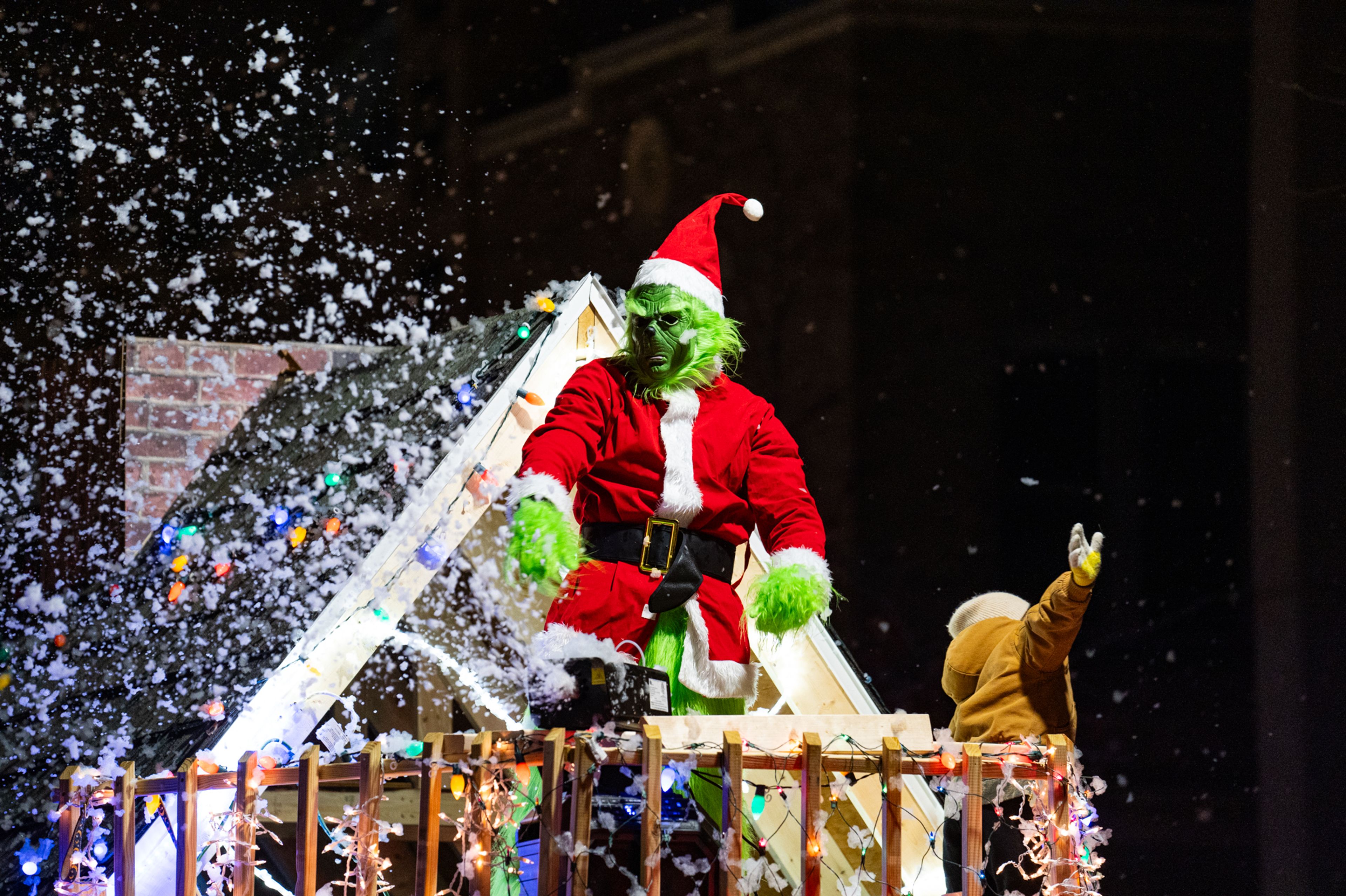 The Grinch appears on the top of 1st Choice Roofing and Construction's parade float on Sunday, Dec. 1.