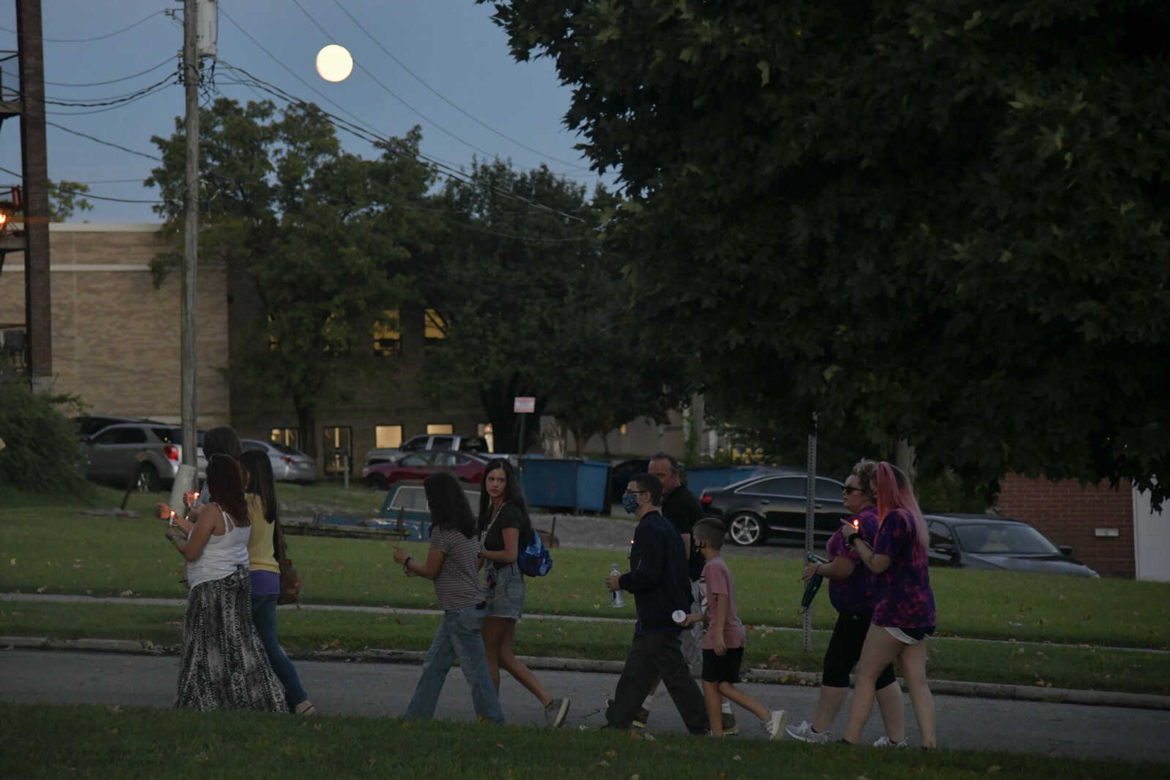 Participants hold candles during the International Overdose Awareness Day Honor Walk on Monday, Aug. 31, 2020, on Houck Place in Cape Girardeau.