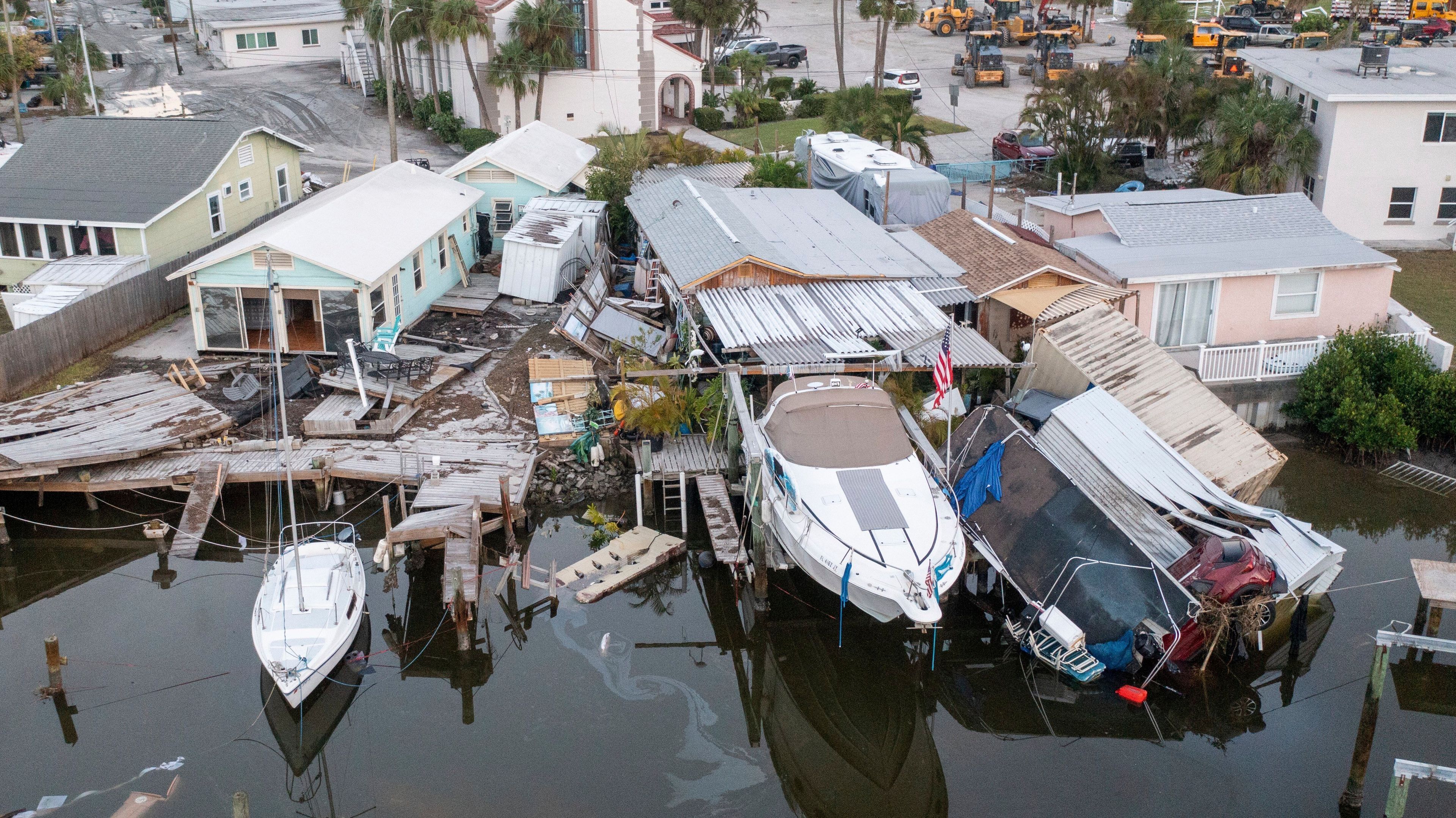 This aerial drone view shows damaged homes and a vehicle collapsed into water after storm surge from Hurricane Helene, Saturday, Sept. 28, 2024, in Madeira Beach, Fla. (Luis Santana/Tampa Bay Times via AP)