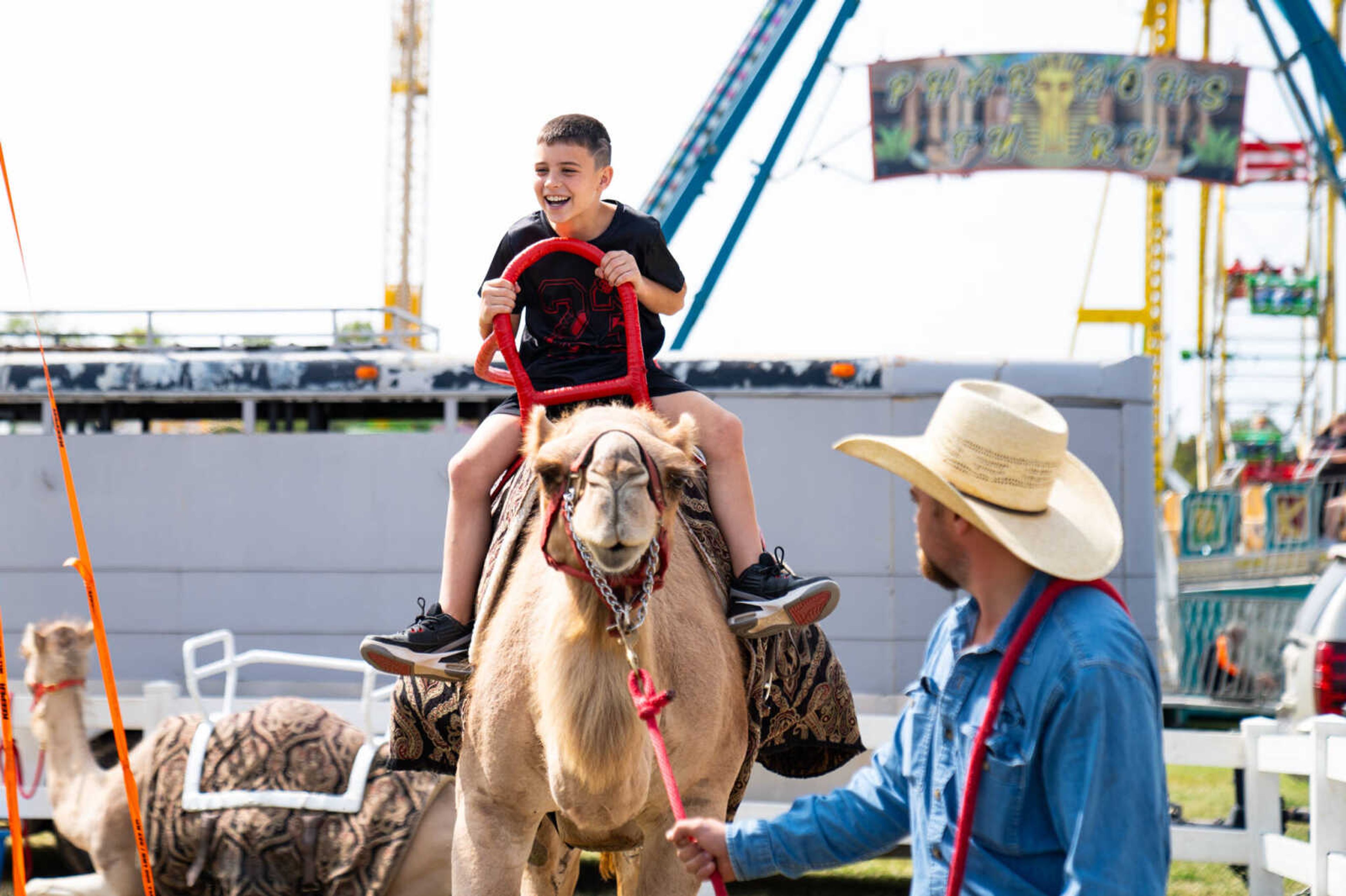 Stetson Overy smiles at his parents while being led around on a camel by Cape Safari's Chance Lantz.