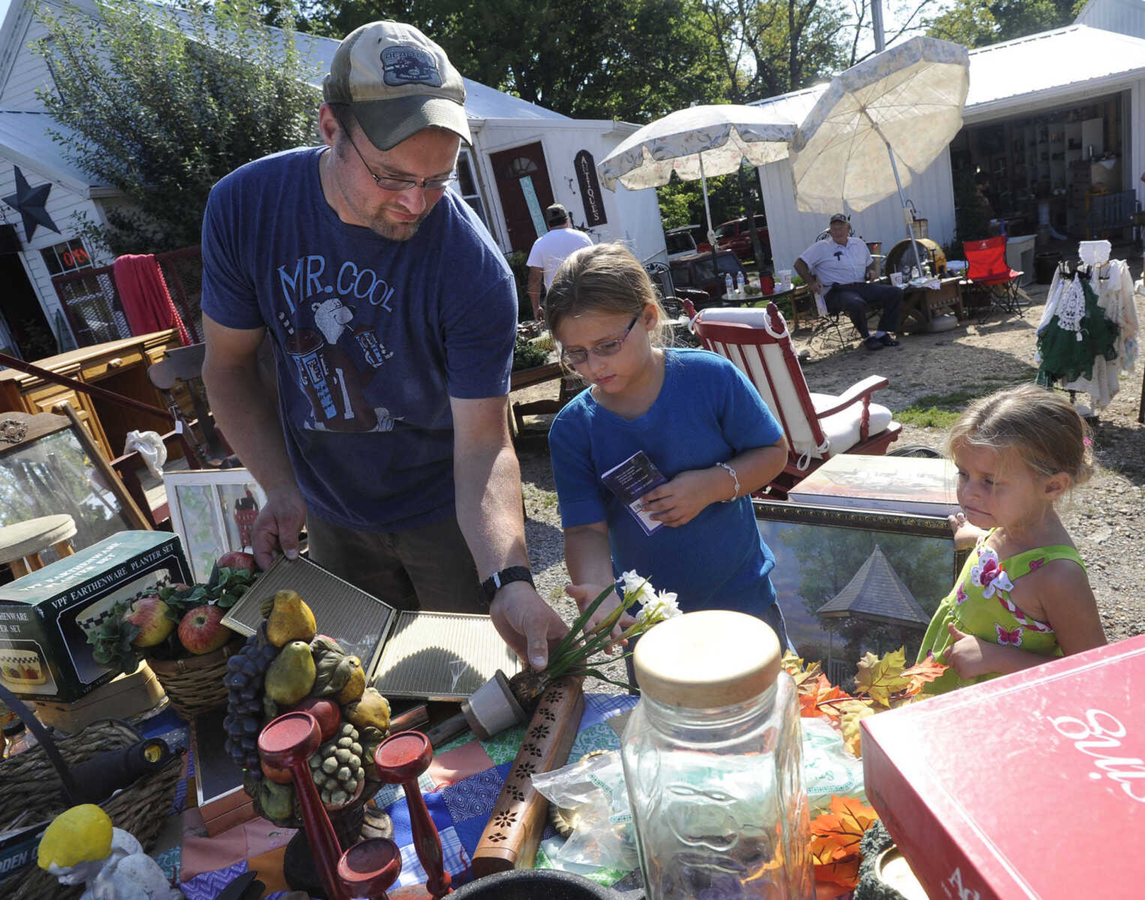 FRED LYNCH ~ flynch@semissourian.com
Eric Bollinger of Fruitland looks at items with his daughters, Hailey, center, and Autumn, at Hubble Creek Antiques and More during the Highway 61 Yard Sale Saturday, Aug. 31, 2013 in Jackson.