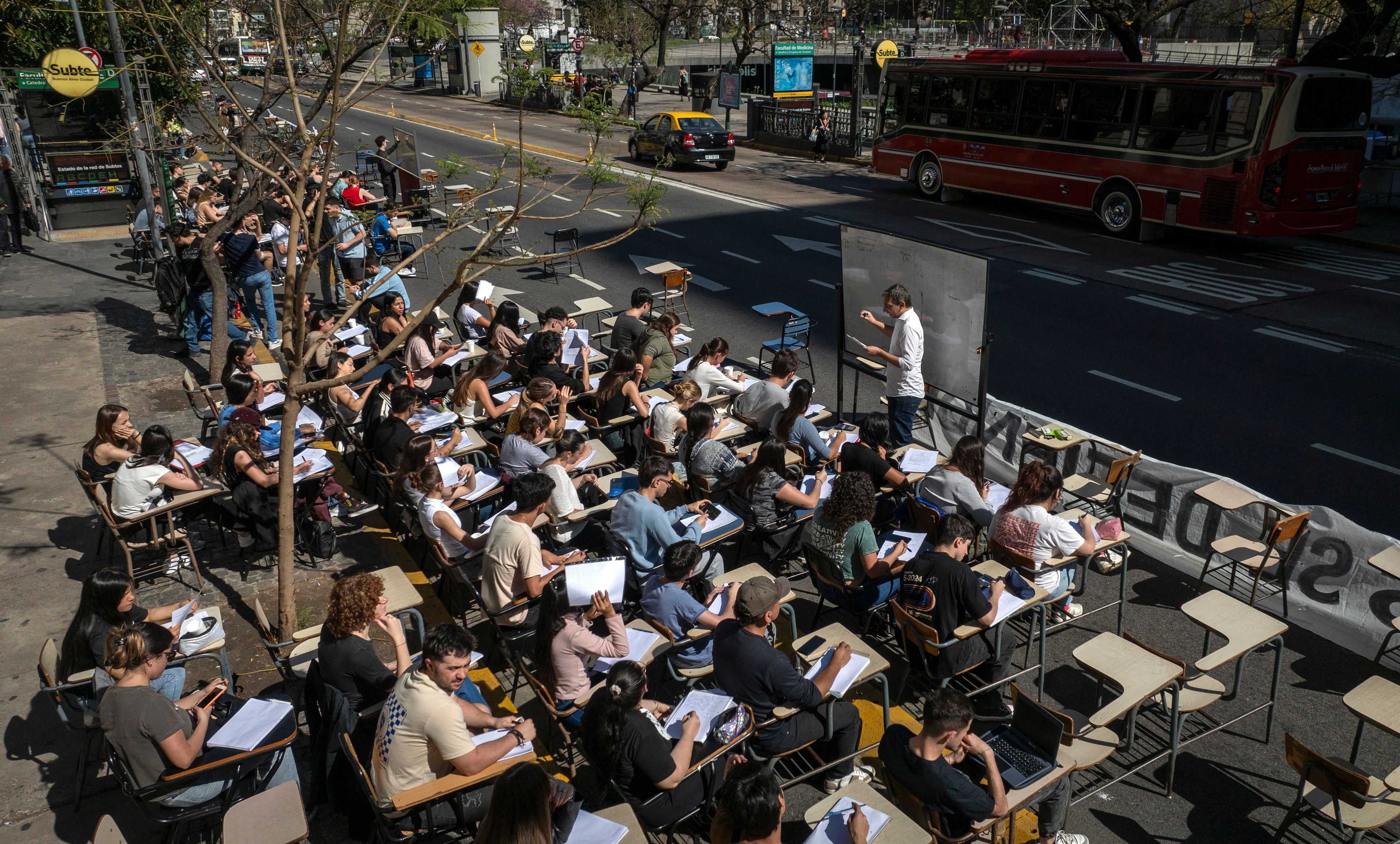 Economics students hold class outside in front of Argentina's University of Buenos Aires to protest President Javier Milei's veto of higher funding for public universities, in Buenos Aires, Wednesday, Oct. 16, 2024. (AP Photo/Victor R. Caivano)