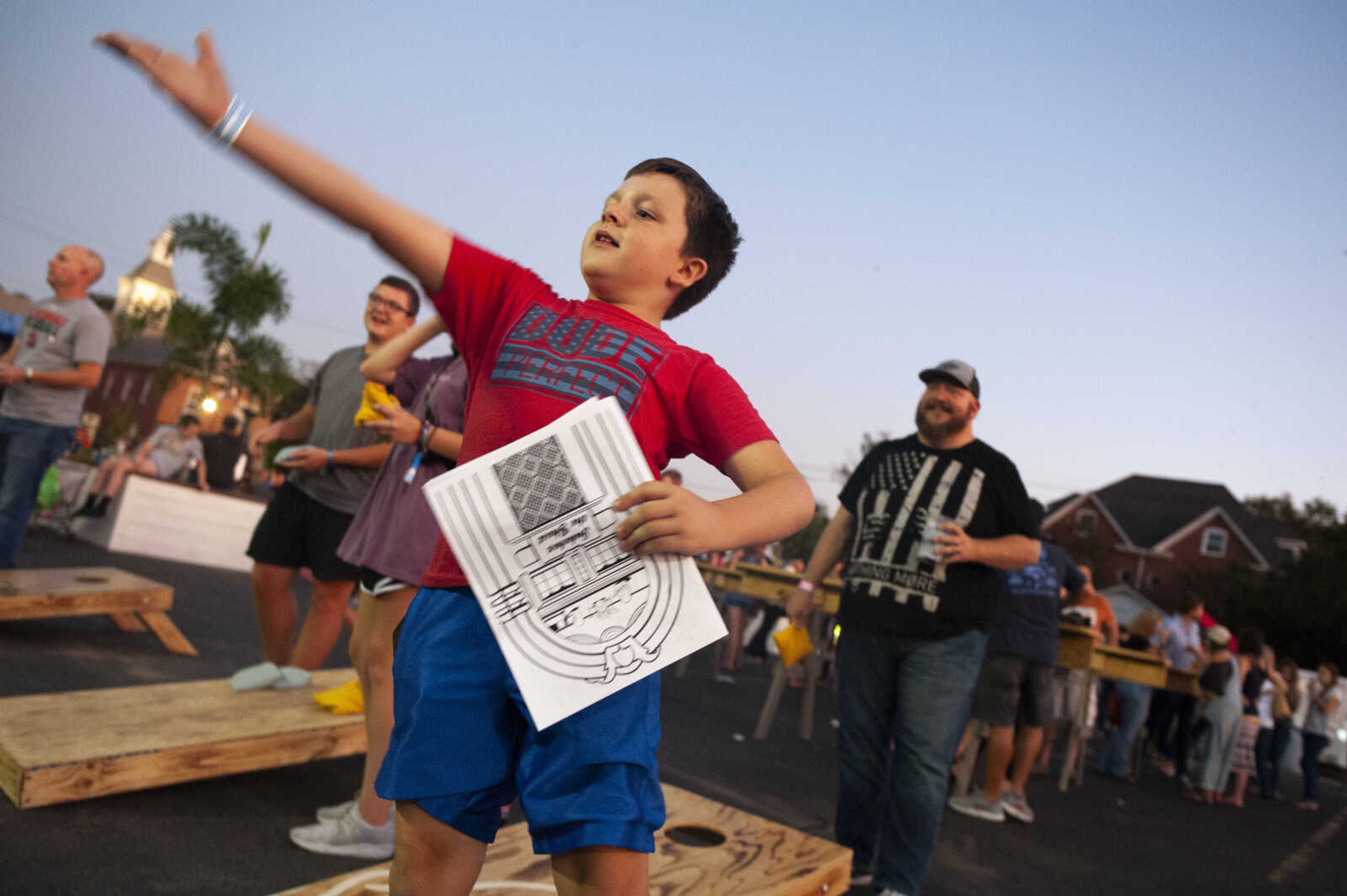 Lawson Burgfeld, 8, of Cape Girardeau, plays bags with his father Darren Burgfeld, in background, during Shipyard Music and Culture Festival on Friday, Sept. 27, 2019, in Cape Girardeau.