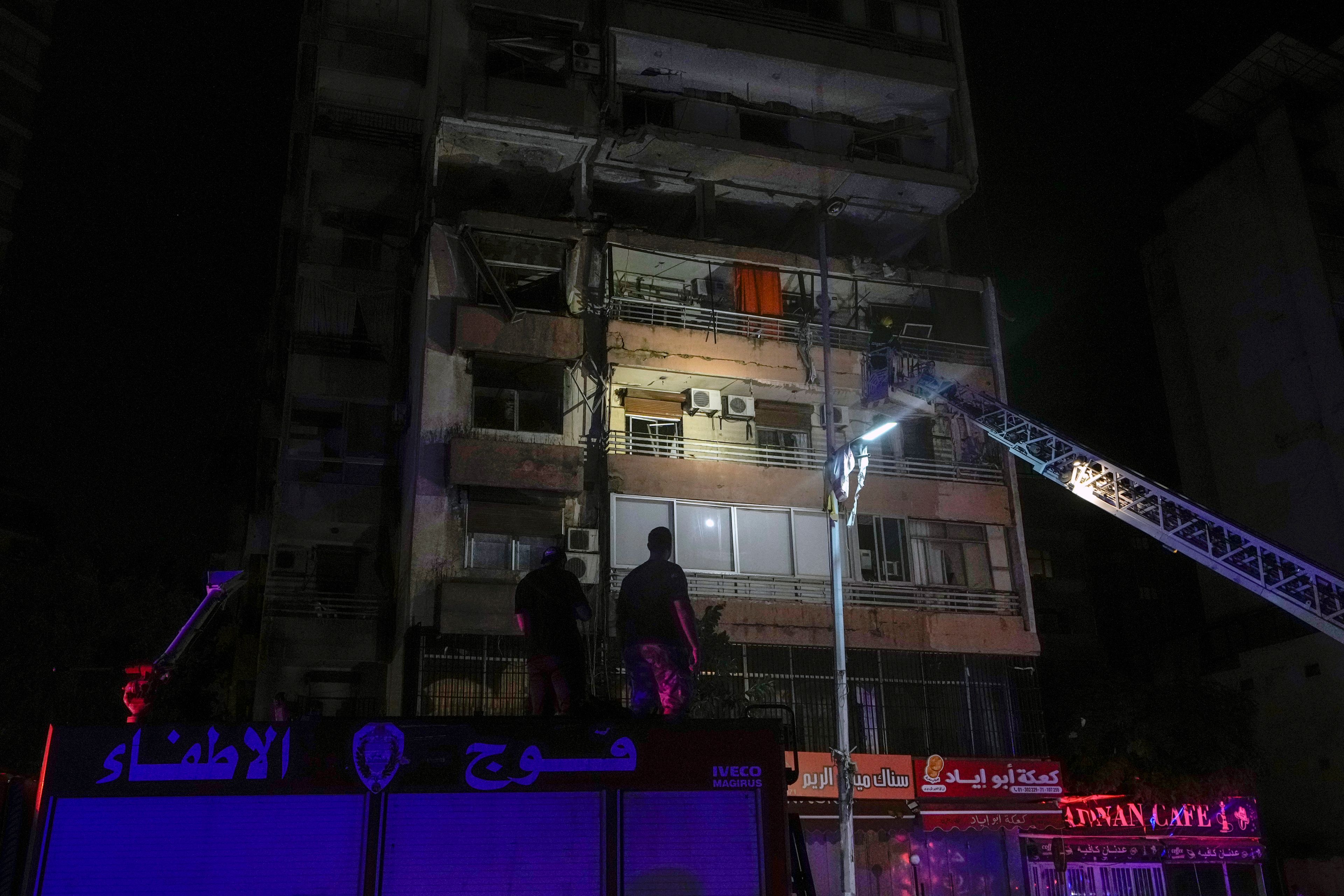 A fire engine ladder extends up a building that was hit in an apparent Israeli airstrike, in central Beirut, Lebanon, early Monday, Sept. 30, 2024. (AP Photo/Bilal Hussein)