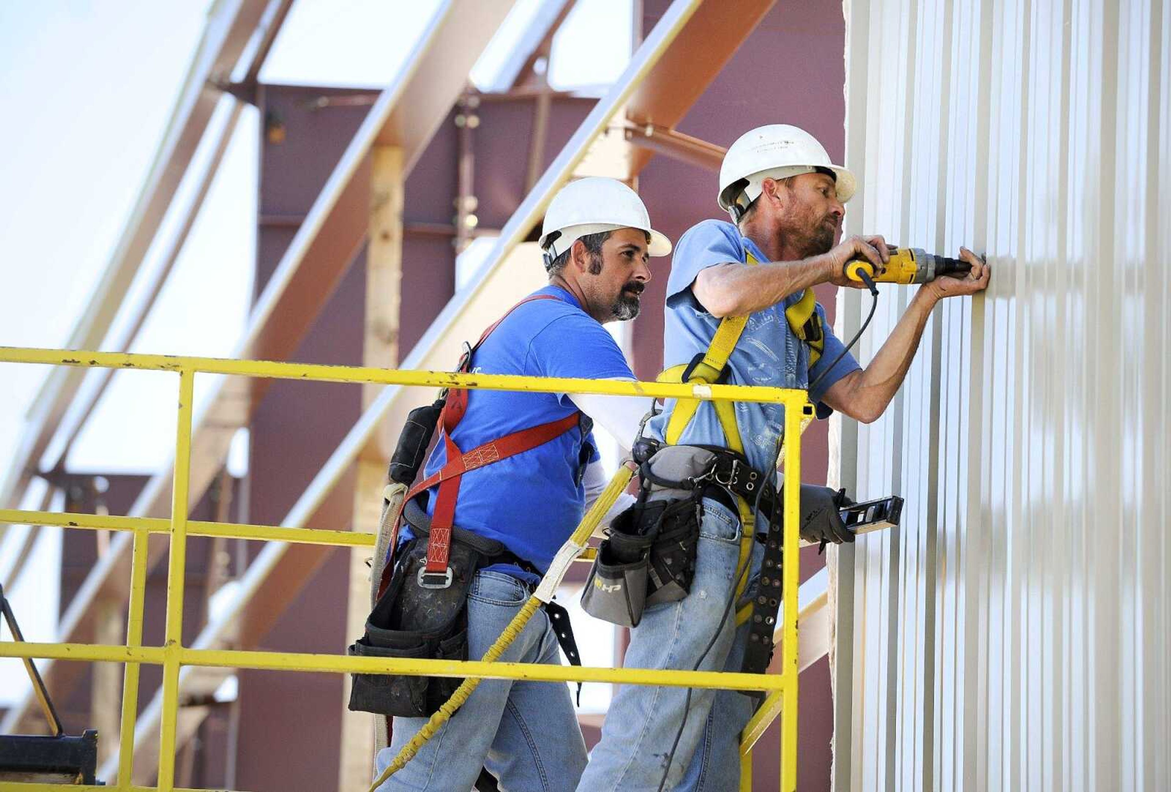 Rob Deimond, right, and Curtis Holt of Scroggins Construction secure siding on an exterior wall Monday of the new expansion at Kohlfield Distributing Inc. in Cape Girardeau.