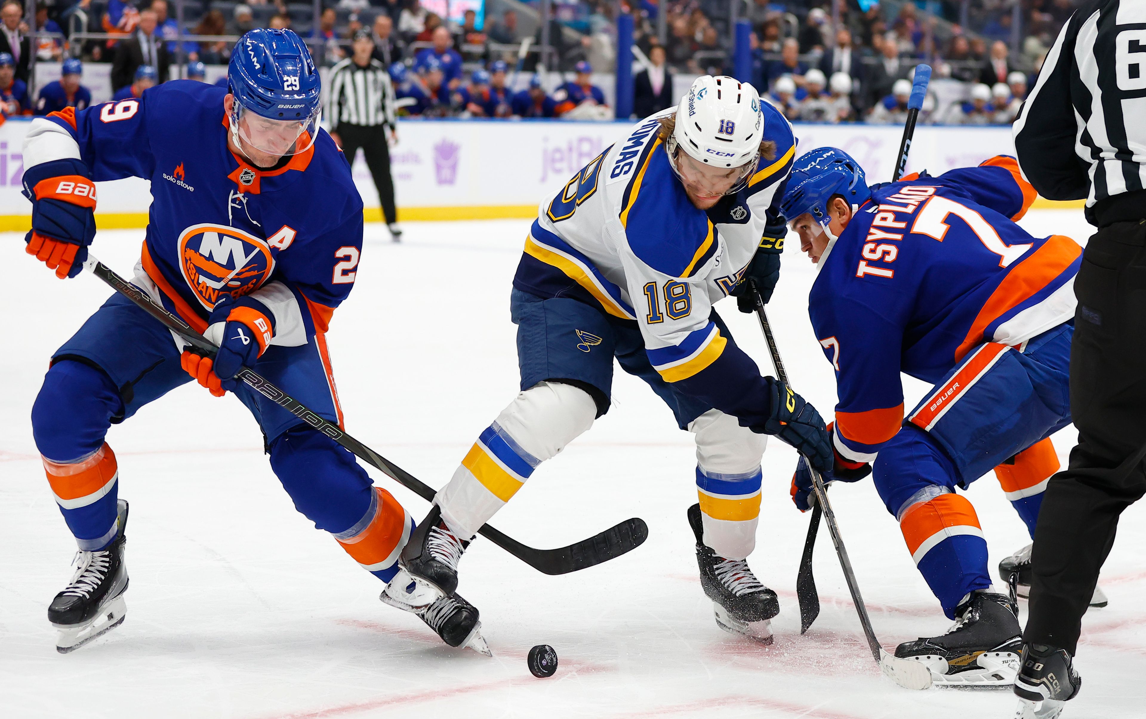 St. Louis Blues center Robert Thomas (18) battle New York Islanders center Brock Nelson (29) and right wing Maxim Tsyplakov (7) for the puck during the second period of an NHL hockey game, Saturday, Nov. 23, 2024, in New York. (AP Photo/Noah K. Murray)