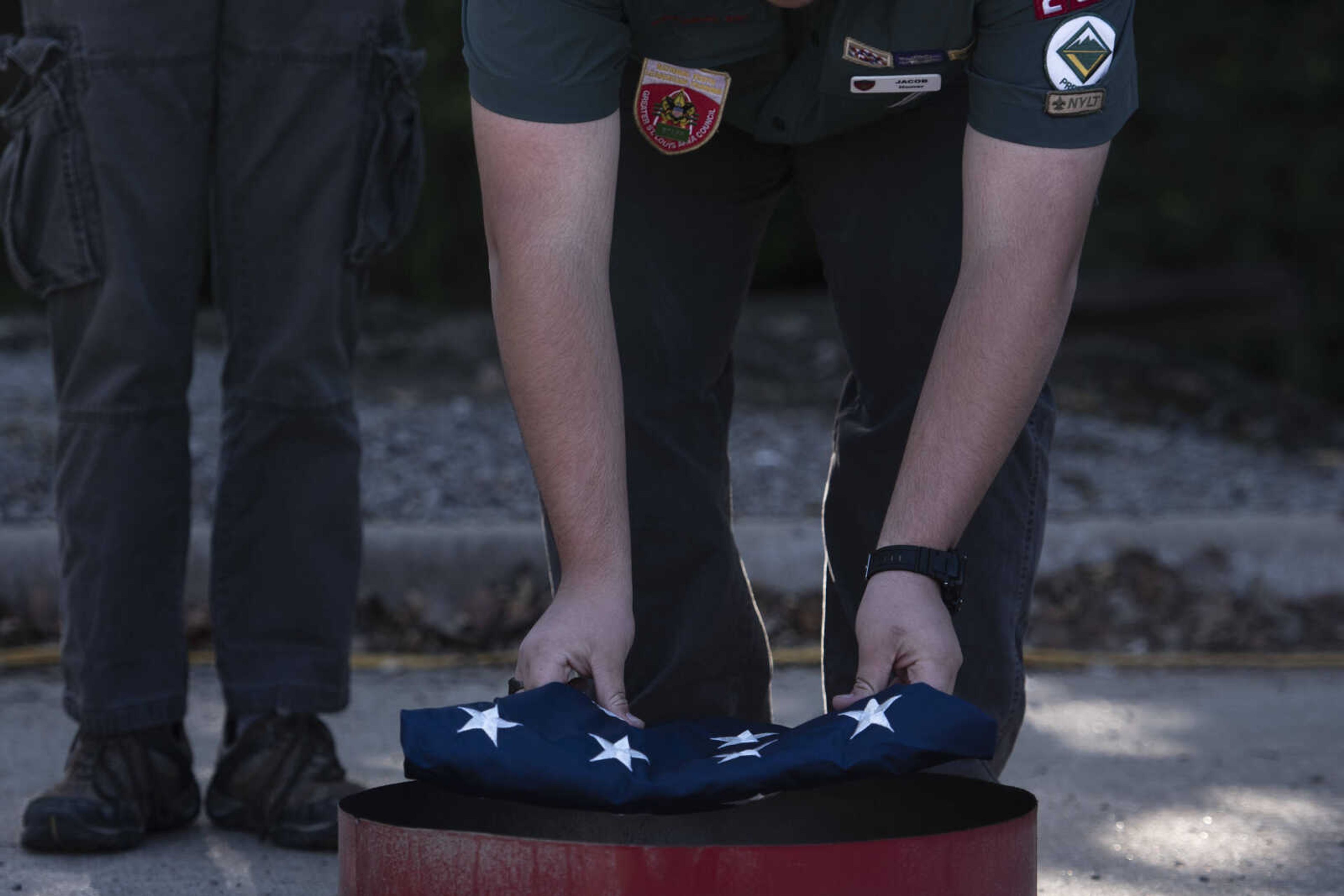 Jacob Homer, of Venture Crew 4005, places a flag on the fire during the inaugural flag retirement ceremony at VFW Post 3838 Sunday, Oct. 21, 2018, in Cape Girardeau.