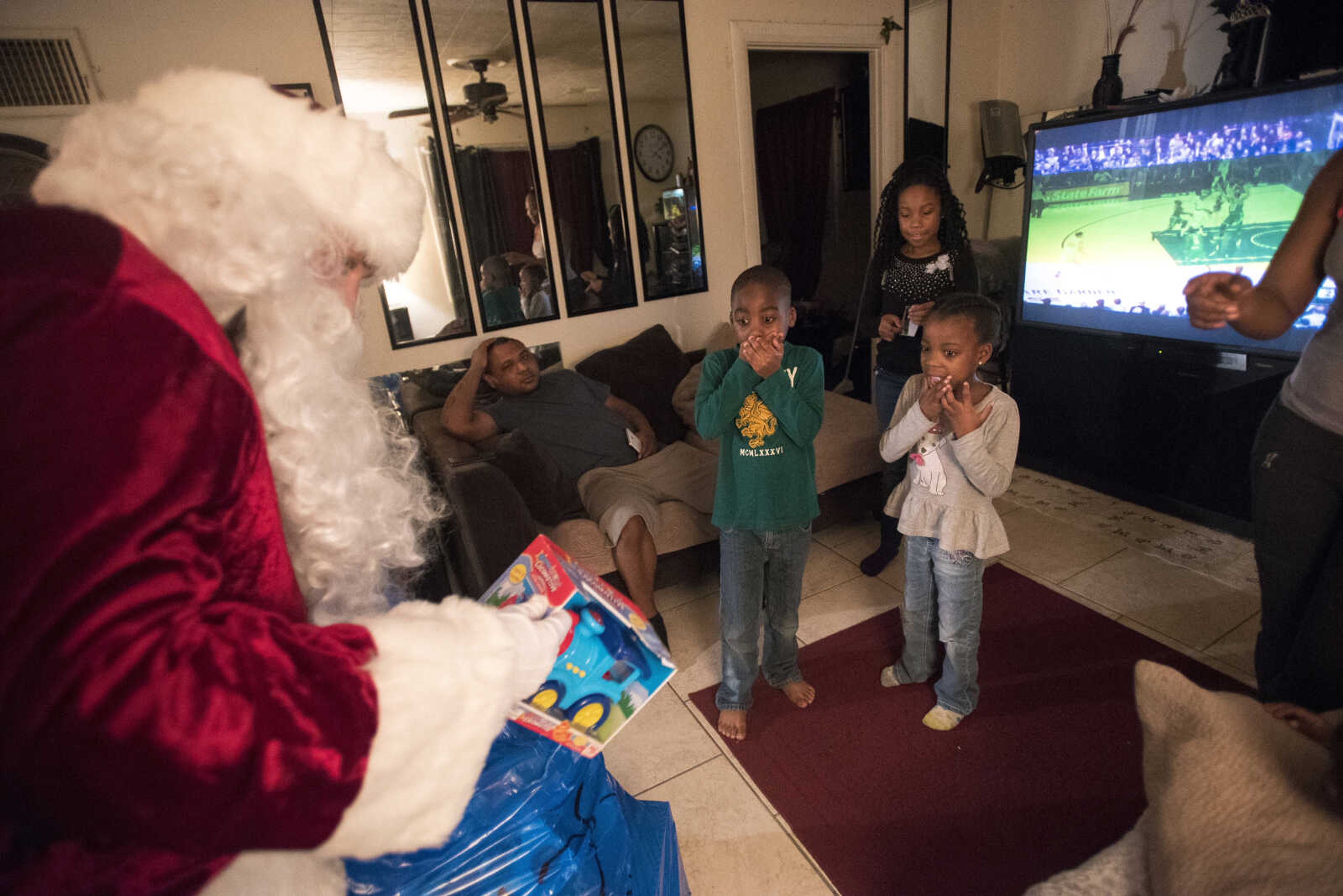 Charlie Wirtle as Santa deliveries presents to kids during the Jaycee Toybox delivery on Thursday, Dec. 22, 2016, in Cape Girardeau.