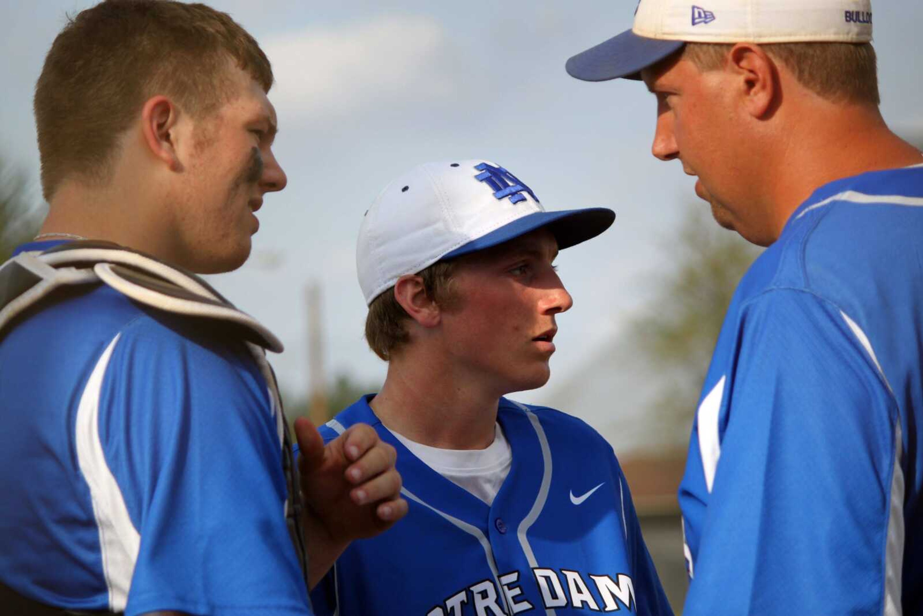 Notre Dame catcher Chase Simmons, left, and pitcher Justin Landewee listen to Bulldogs coach Jeff Graviett during a meeting on the mound Friday in Kennett, Mo. (DUSTIN WARD ~ Daily Dunklin Democrat)