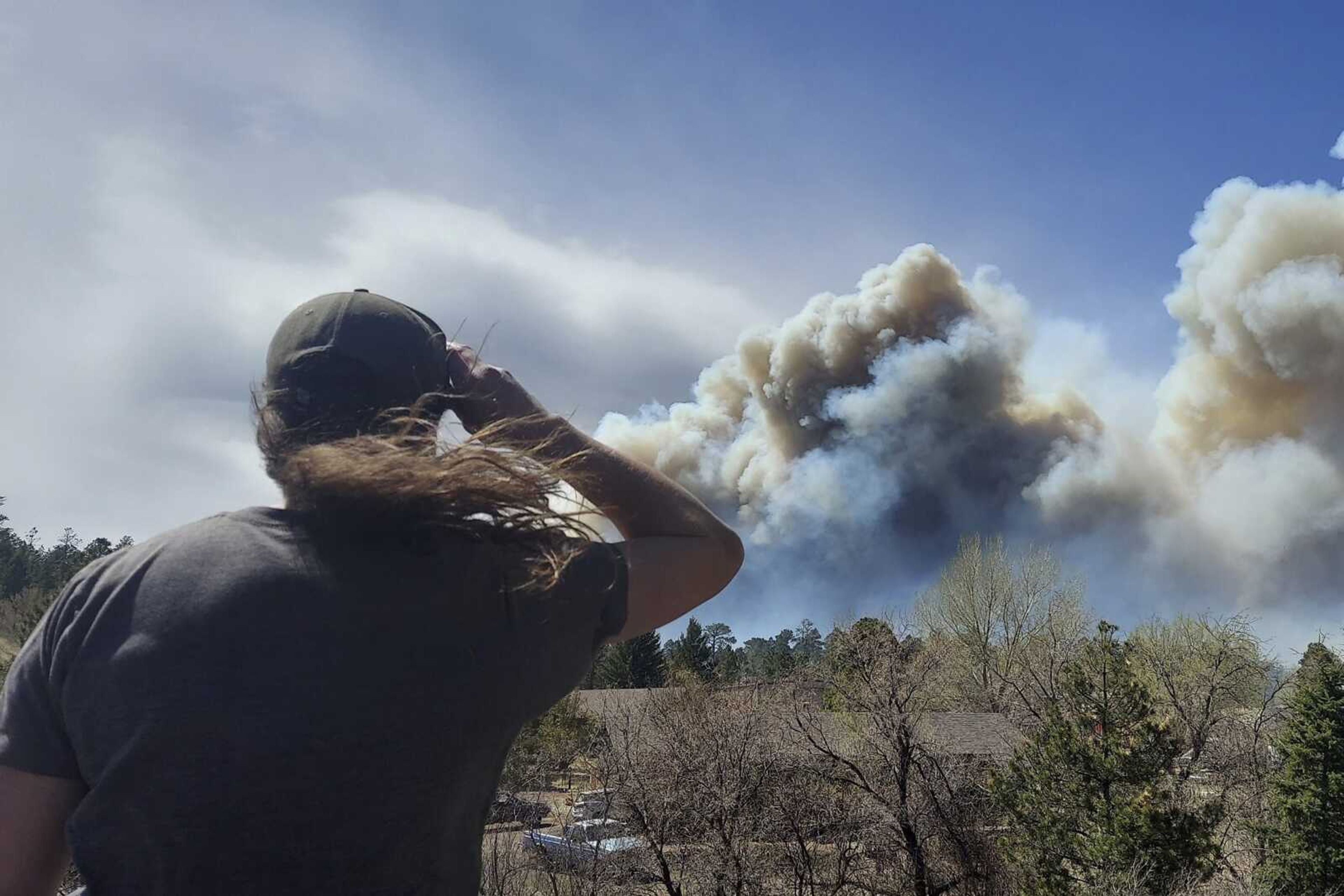 Smoke from a wind-whipped wildfire rises above neighborhoods Tuesday on the outskirts of Flagstaff, Arizona. Authorities issued evacuation orders for a couple hundred homes.