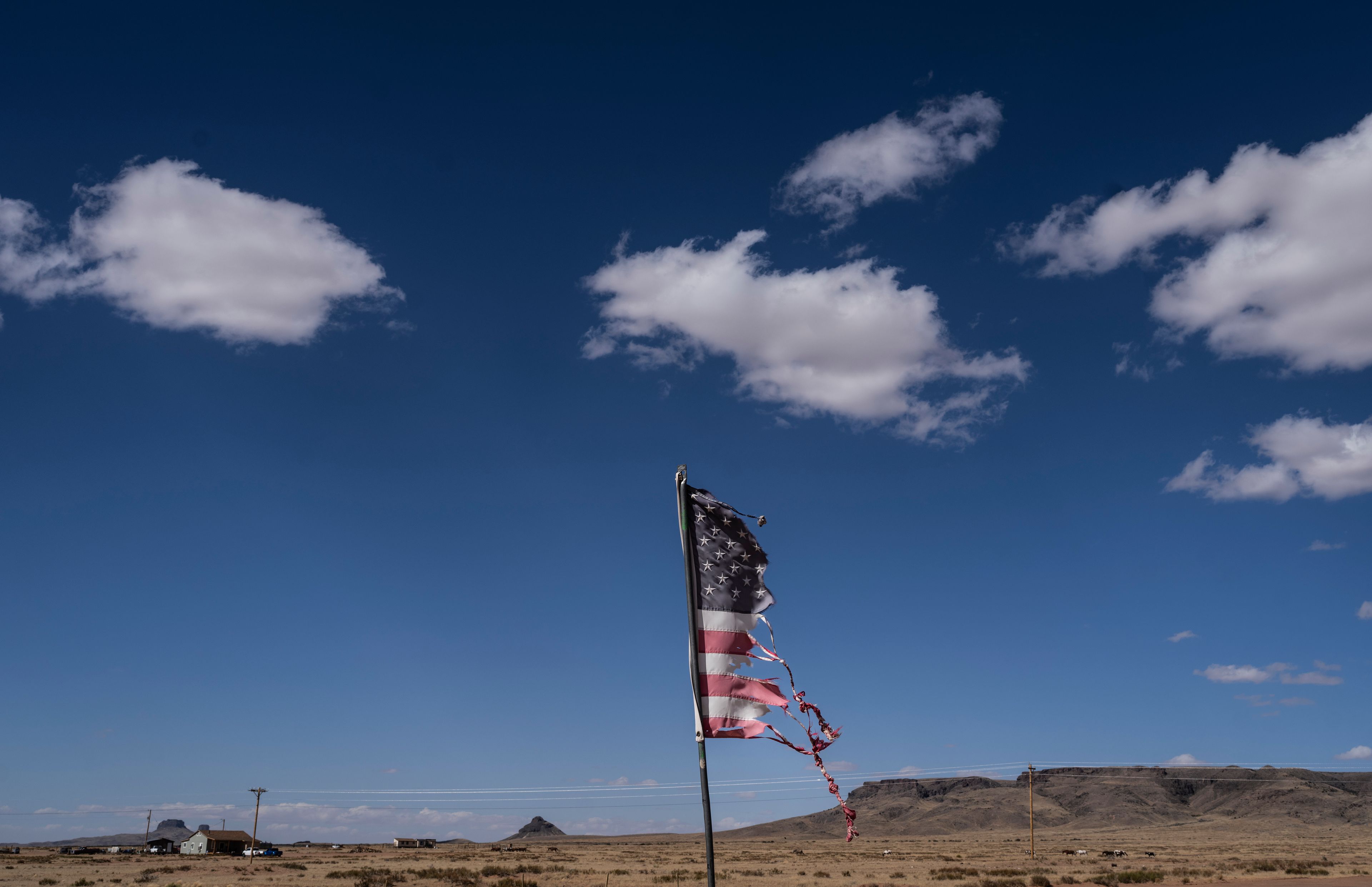 A battered U.S. flag flutters in the wind on the Navajo Nation in Dilkon, Ariz., Thursday, Oct. 17, 2024.(AP Photo/Rodrigo Abd)