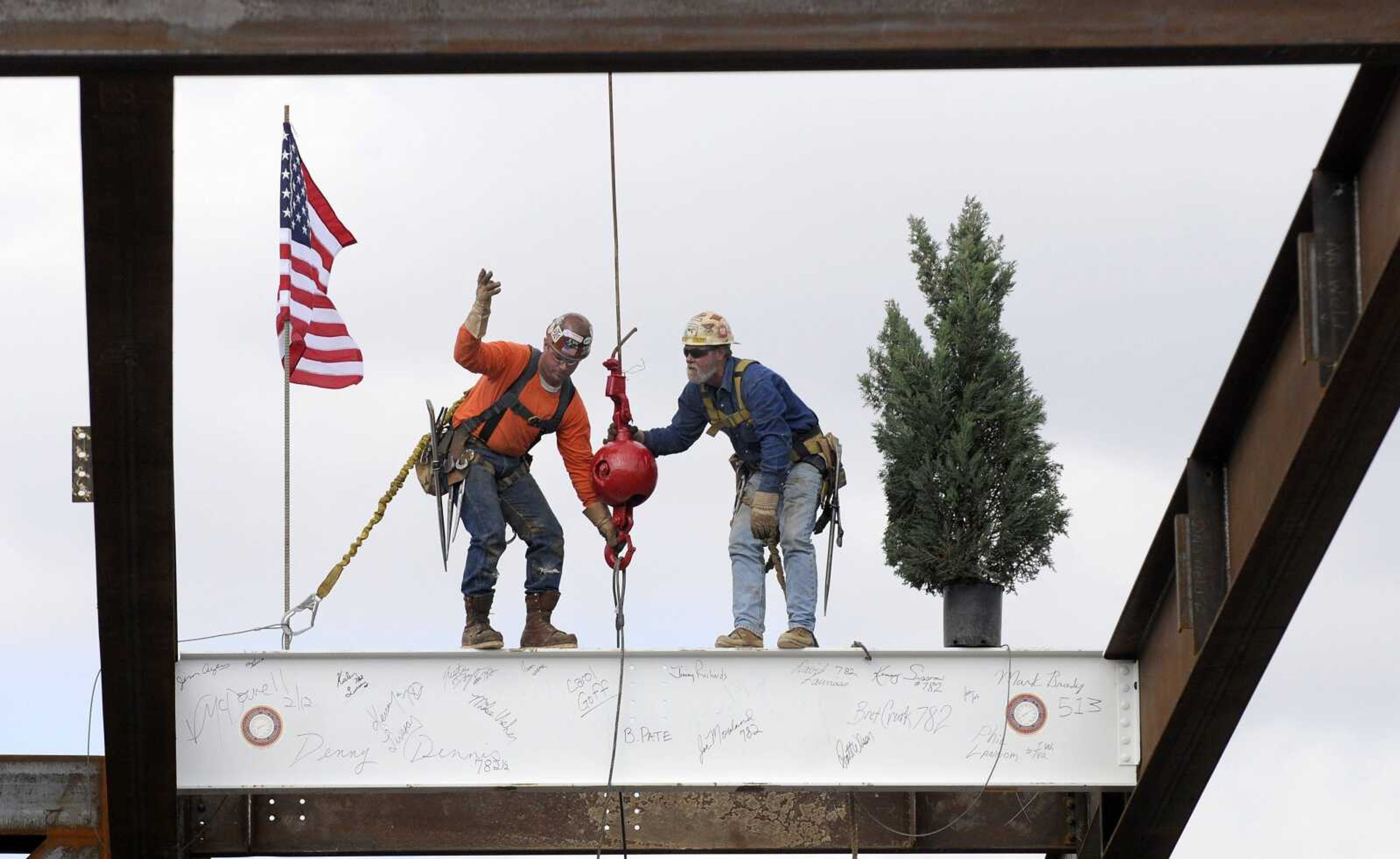 In this file photo, Brandon Pate, left, and Phil Lannom release the steel beam from the crane after securing it into position at the Isle of Capri casino site on Thursday, Feb. 23, 2012, in Cape Girardeau. A ceremony was held to commemorate the placement of the beam, which was signed by dignitaries and members of the community. An evergreen tree and American flag were placed on the beam as it was hoisted, in keeping with a good luck tradition. The casino is set to open around Thanksgiving of this year. (Kristin Eberts)