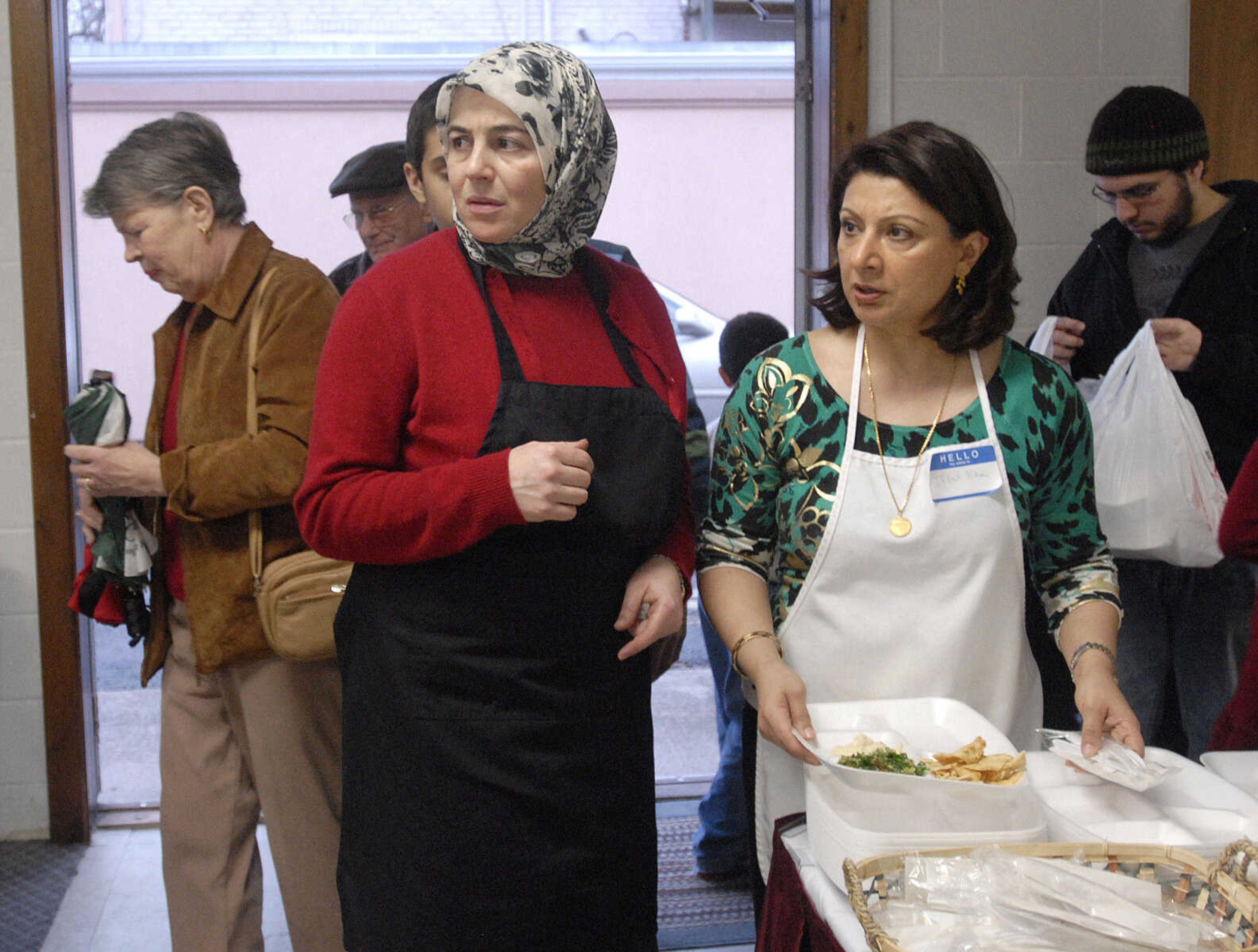 LAURA SIMON~lsimon@semissourian.com
Rania Roumany, left, and Iffat Khan watch the room fills with visitors Sunday, February 21, 2010 during the Islamic Center's Haiti benefit dinner in Cape Girardeau.