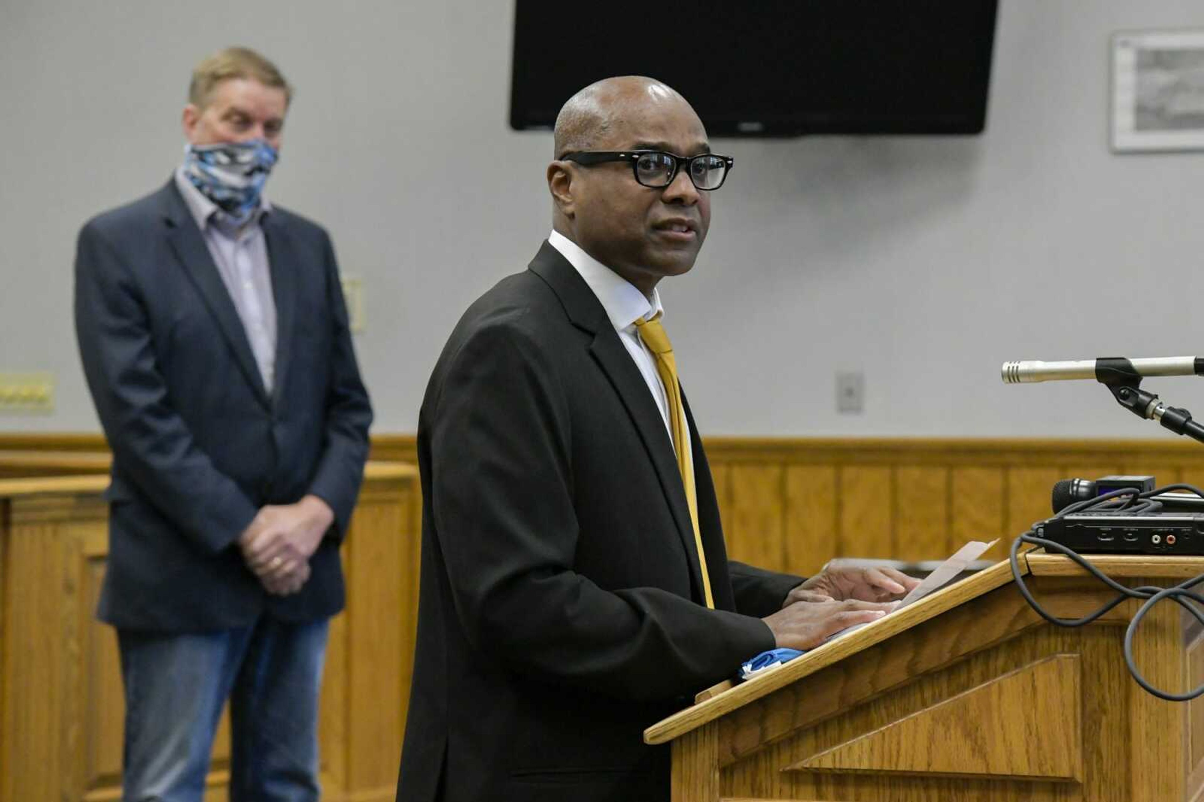 Incoming city manager Kenneth Haskin speaks at Thursday's news conference while the outgoing manager, Scott Meyer, back left, watches in the chambers of the Cape Girardeau City Council in Cape Girardeau.