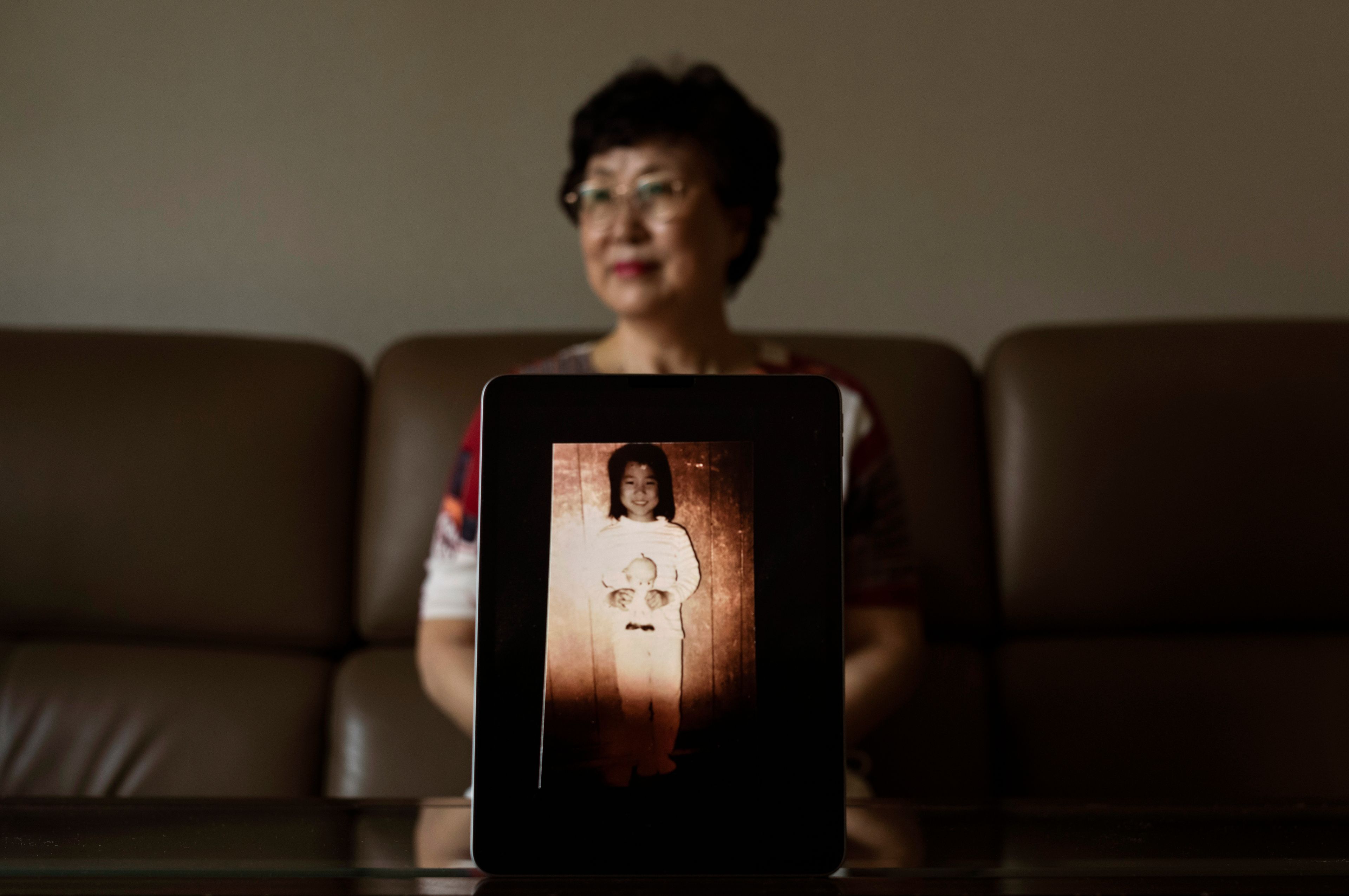 Han Tae-soon, sits for a photo with a computer tablet displaying an old photo of her daughter, at her home in Anyang, South Korea, Saturday, June 1, 2024. Han's daughter went missing and she searched for her for years, only to discover later she'd been adopted to the United States. (AP Photo/Jae C. Hong)