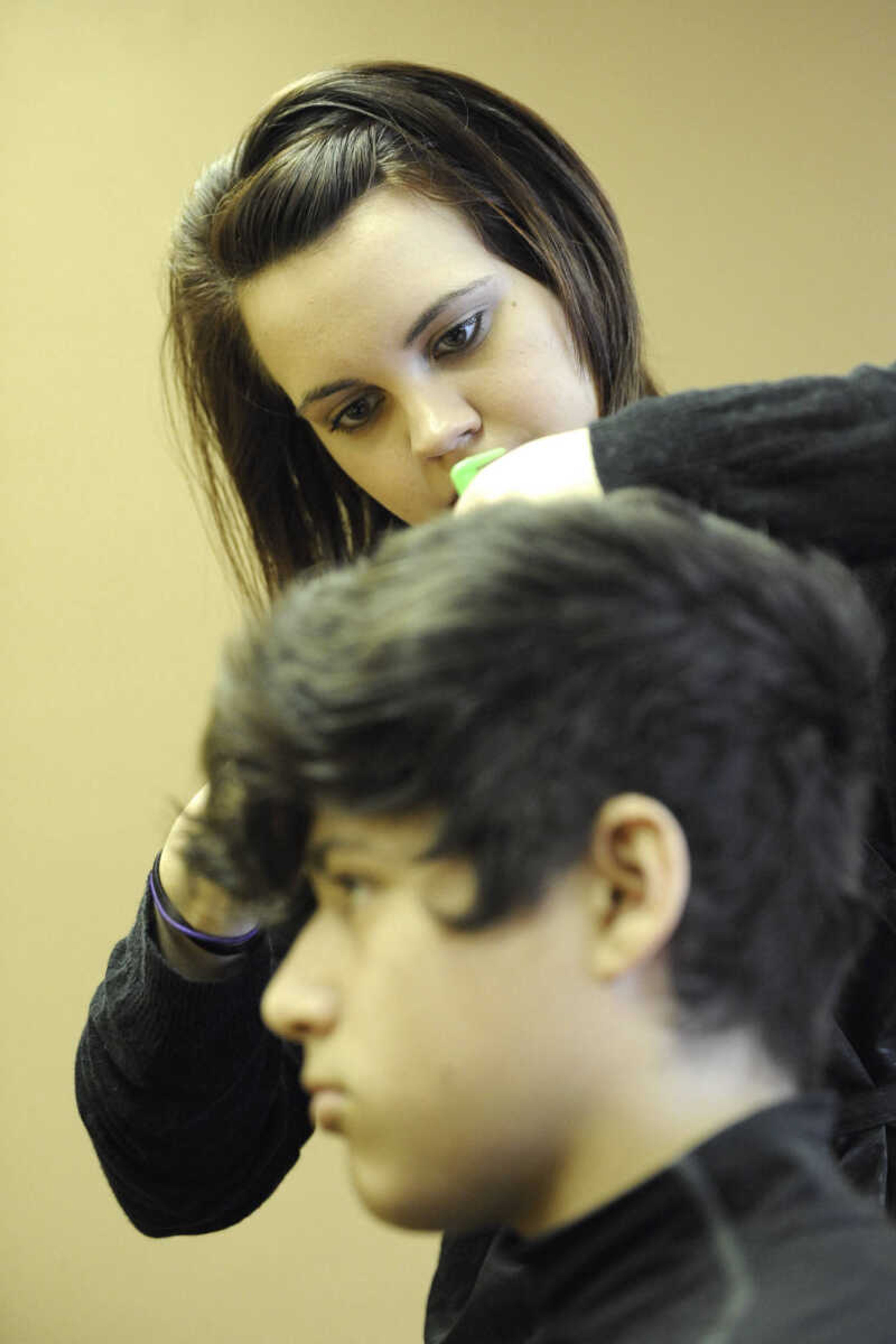 GLENN LANDBERG ~ glandberg@semissourian.com

Kristin Fritsche cuts Jacob Moreno's hair before his family photo session at the Help-Portrait event Saturday, Dec. 6, 2014 at the House of Hope in Cape Girardeau.