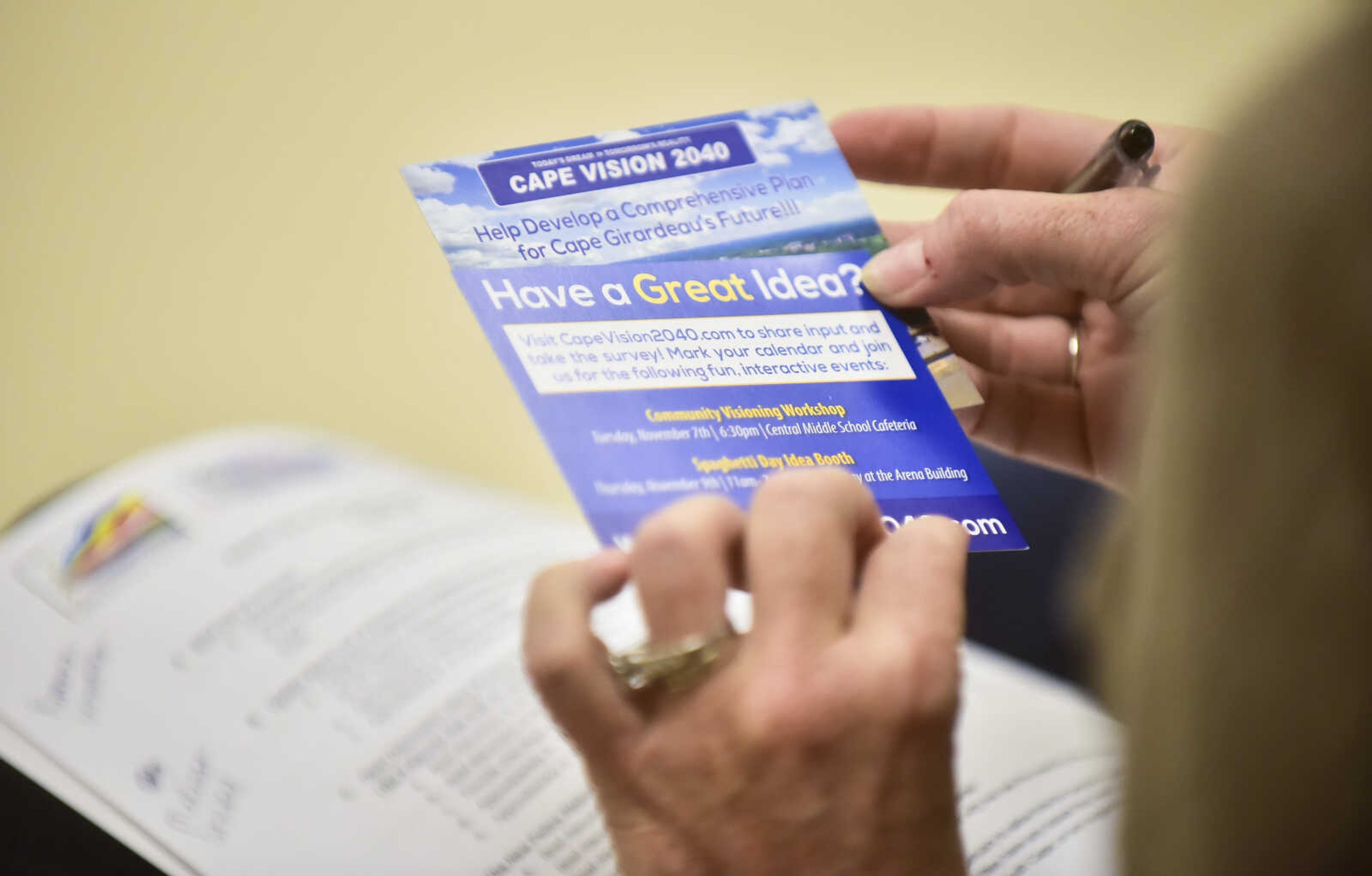 A community member holds up a card with the comprehensive plan called Cape Vision 2040 while listening to Ryan Shrimplin speak during a community workshop meeting held by the Authentic Voices group of south Cape Thursday, Oct. 26, 2017 at the Shawnee Park Center in Cape Girardeau.