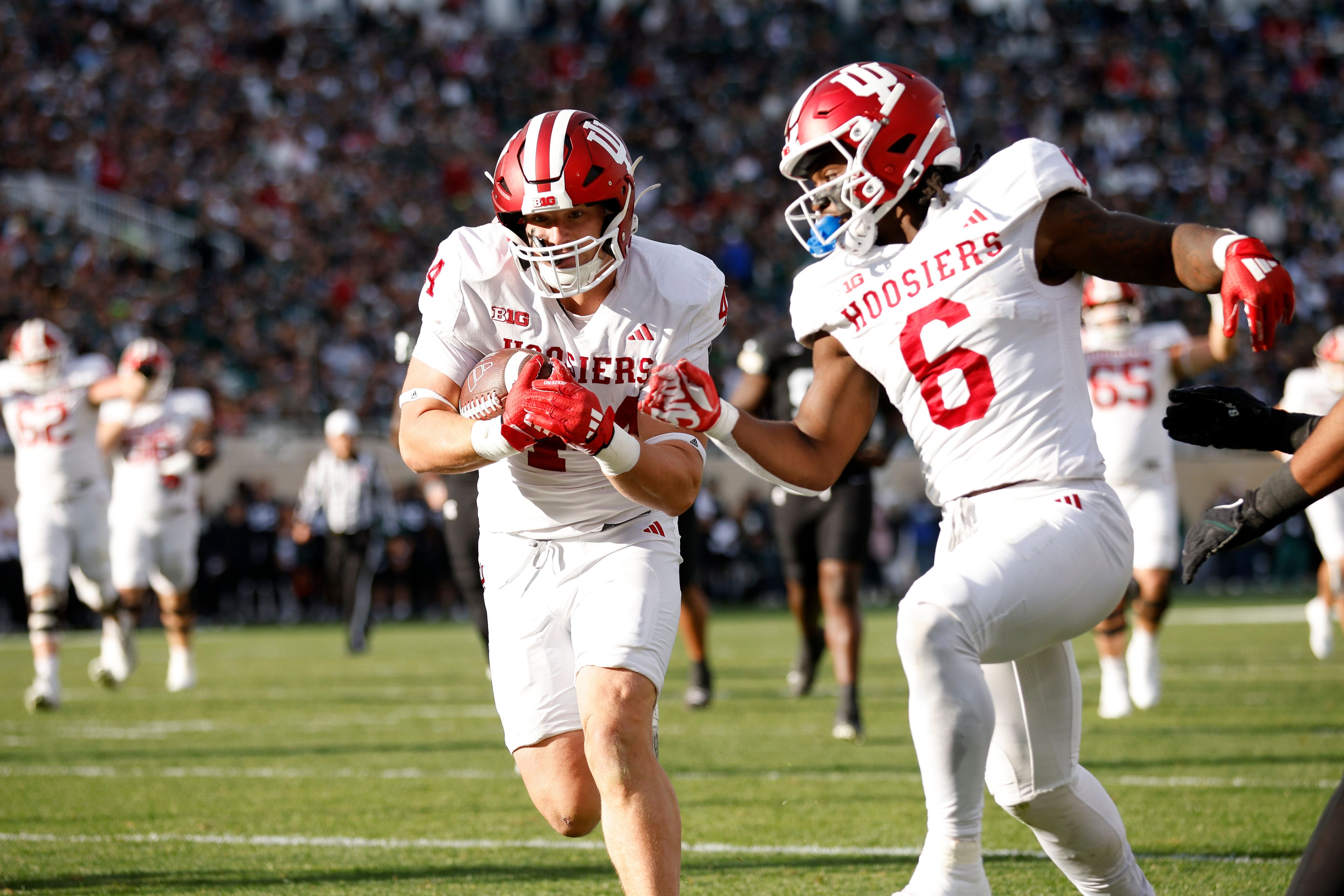 Indiana tight end Zach Horton, left, scores on a pass reception as Indiana running back Justice Ellison (6) looks on during the first half of an NCAA college football game against Michigan State, Saturday, Nov. 2, 2024, in East Lansing, Mich. (AP Photo/Al Goldis)