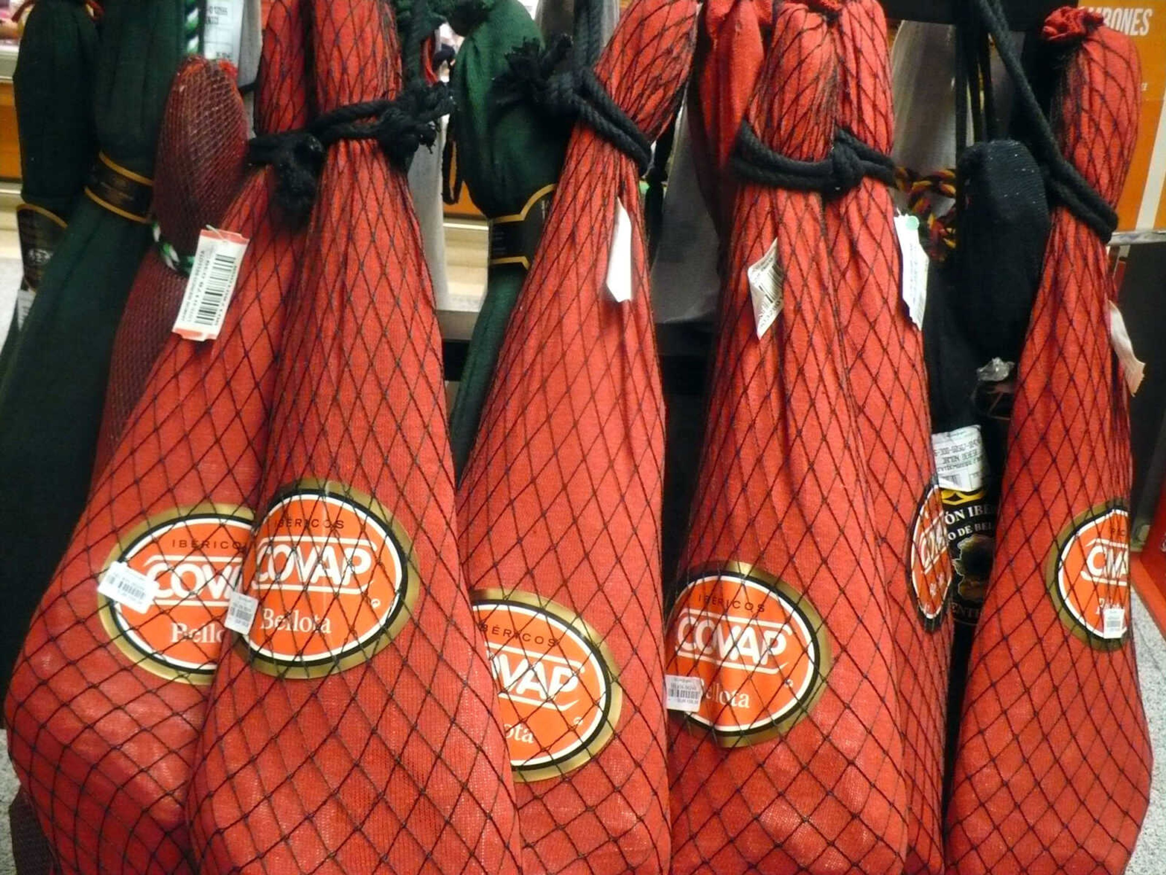 Gourmet Spanish hams, cured, bagged, and waiting for purchase at a typical Spanish gourmet grocery.