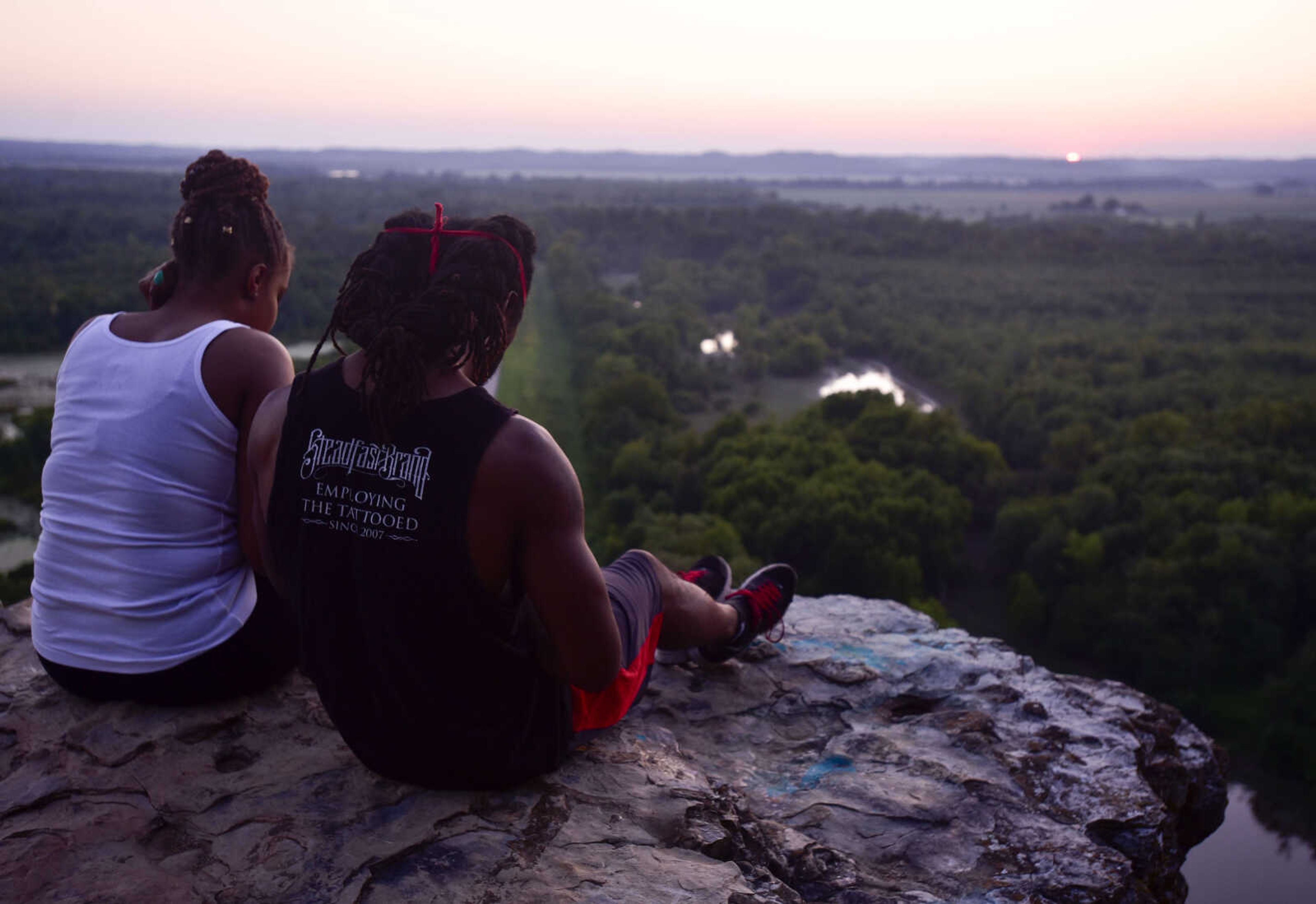 Visitors watch from the Inspiration Point overlook as the sun sets behind the horizon Wednesday, Aug. 1, 2018, near Wolf Lake, Illinois.