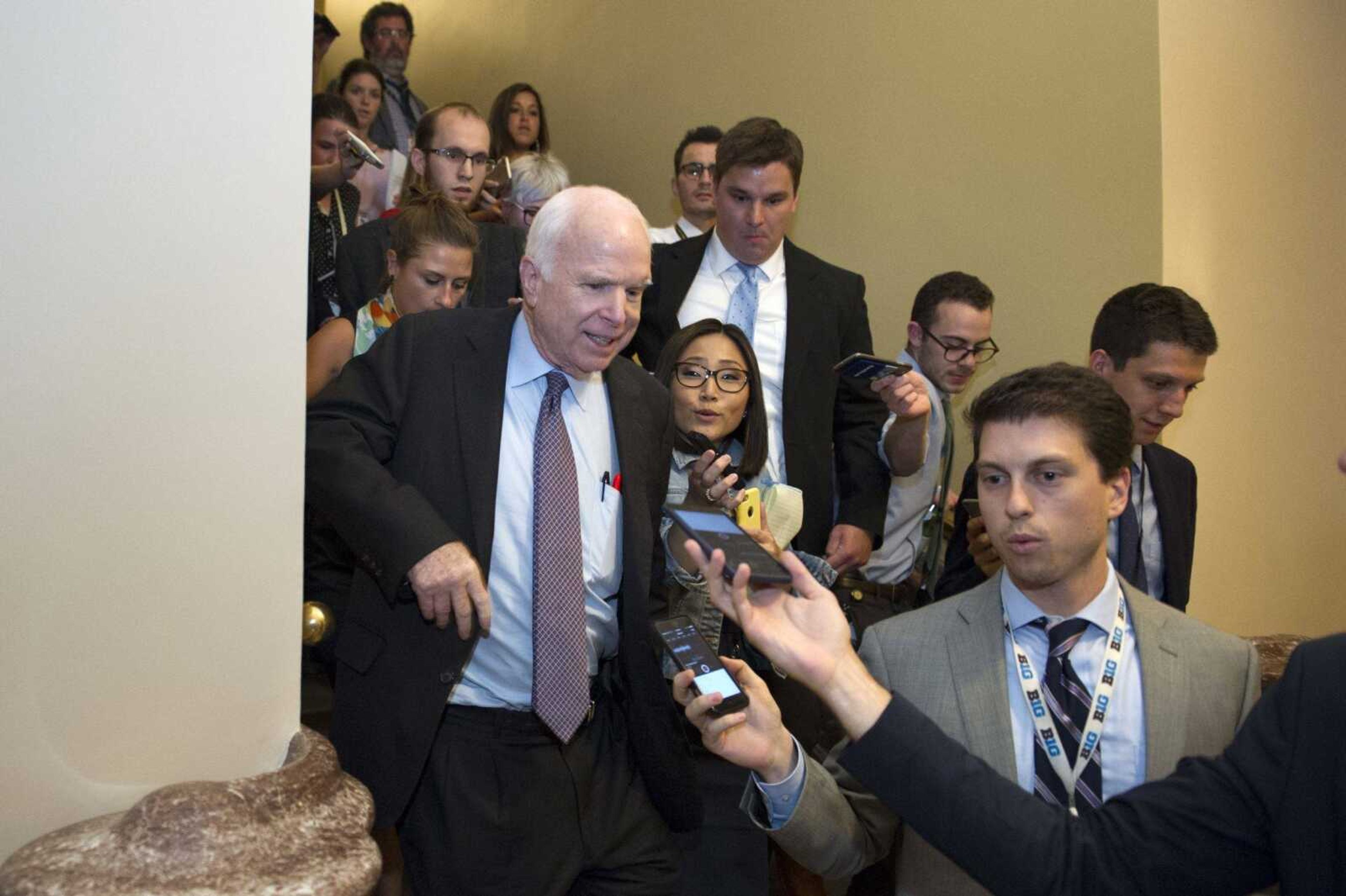 Sen. John McCain, R-Ariz., is pursued by reporters Friday on Capitol Hill in Washington. Conservatives across the country are warning the GOP-led Congress cannot abandon its pledge to repeal "Obamacare" without triggering a political nightmare in next year's midterm elections.