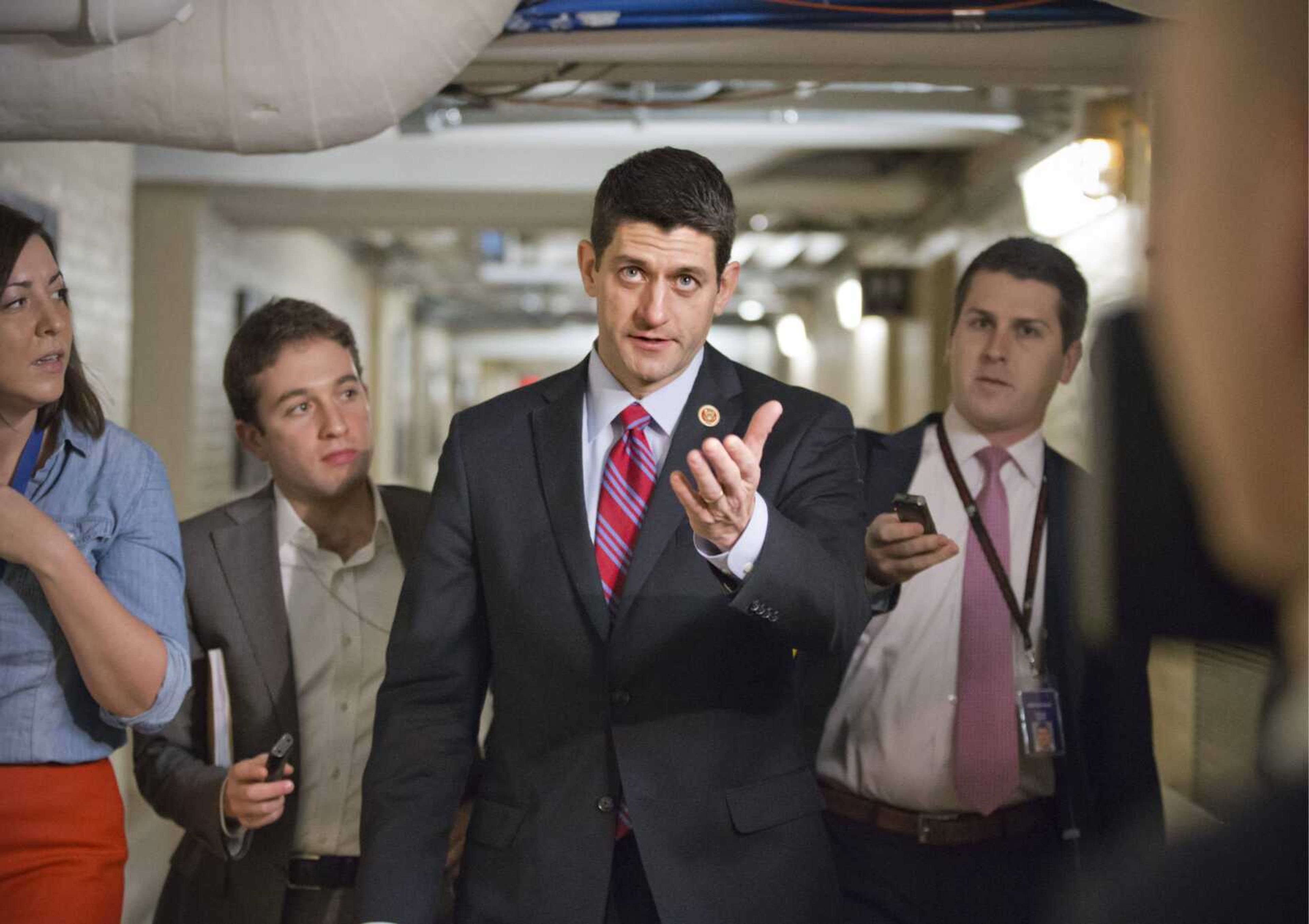 Walking through a basement corridor Wednesday on Capitol Hill, House Budget Committee chairman Paul Ryan, R-Wis., talks to reporters the morning after a budget deal was worked out between him and Senate Budget Committee chairwoman Patty Murray, D-Wash. (J. Scott Applewhite ~ Associated Press)