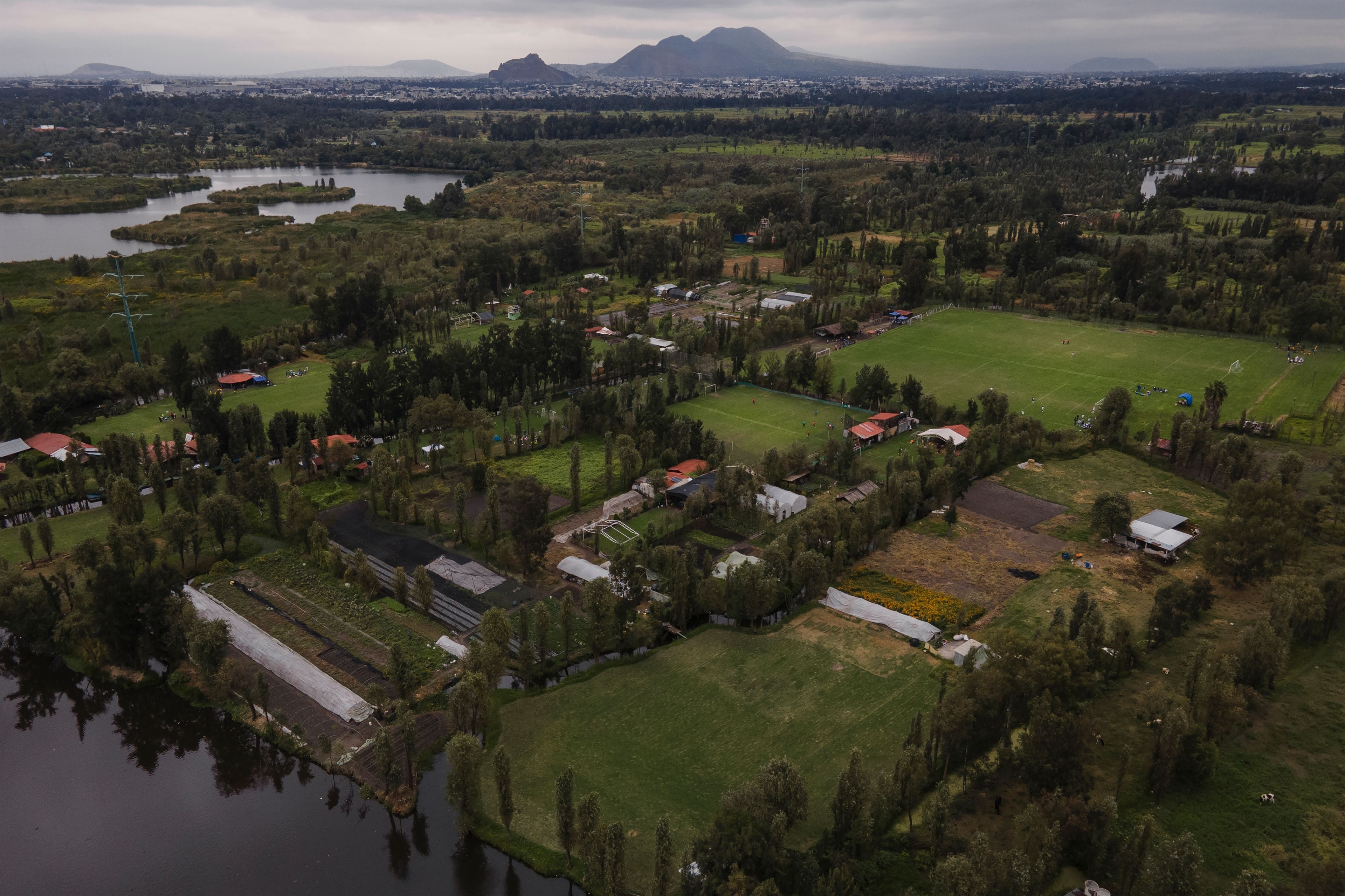 Small ancestral floating gardens are visible next to new soccer fields on the Xochimilco Lake in the Xochimilco borough of Mexico City, on Sunday, Oct. 20, 2024. (AP Photo/Felix Marquez)