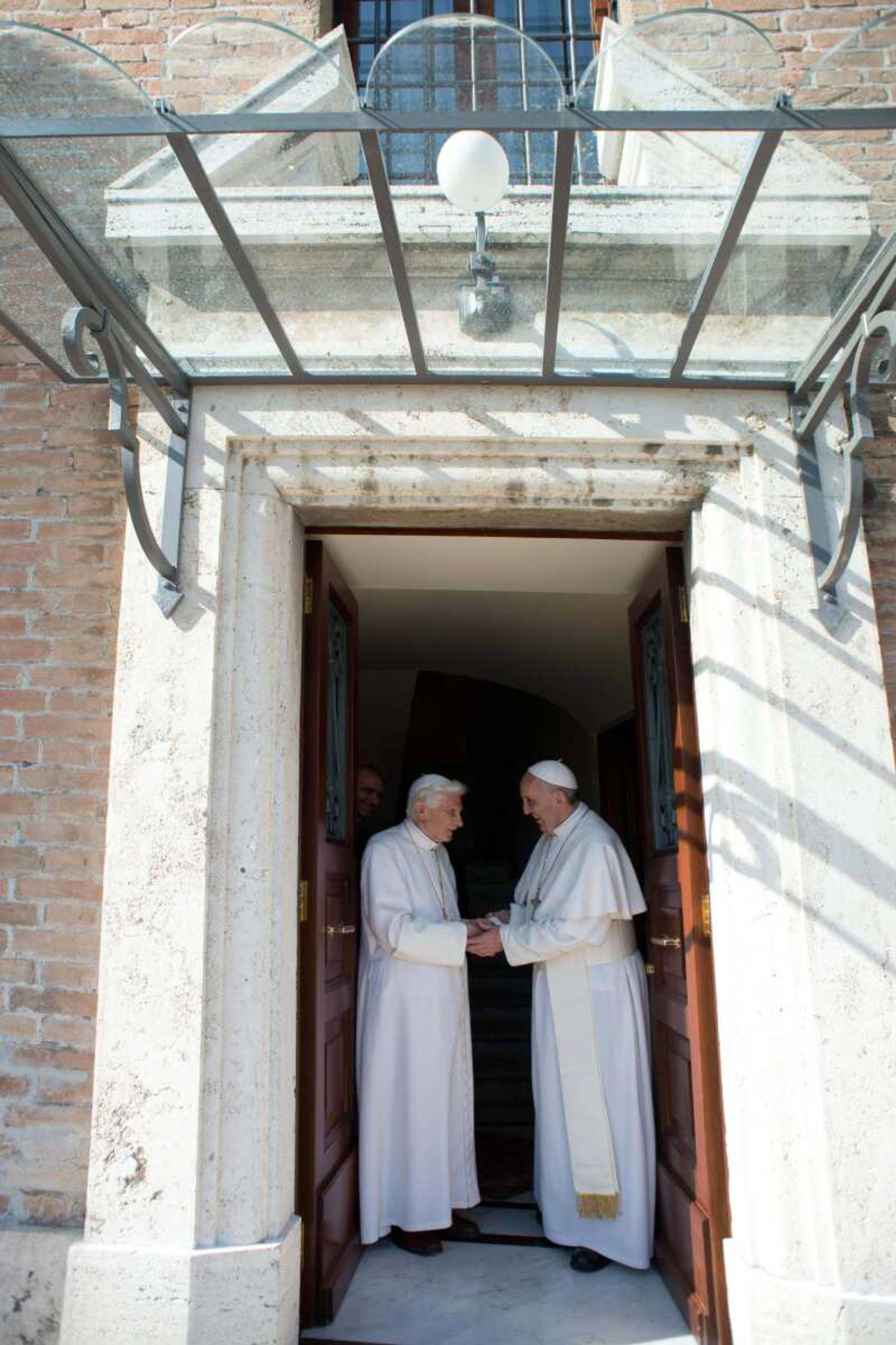 Pope emeritus Benedict XVI, left, is welcomed by Pope Francis as he returns Thursday to the Vatican from the pontifical summer residence of Castel Gandolfo. (Osservatore Romano ~ Associated Press)