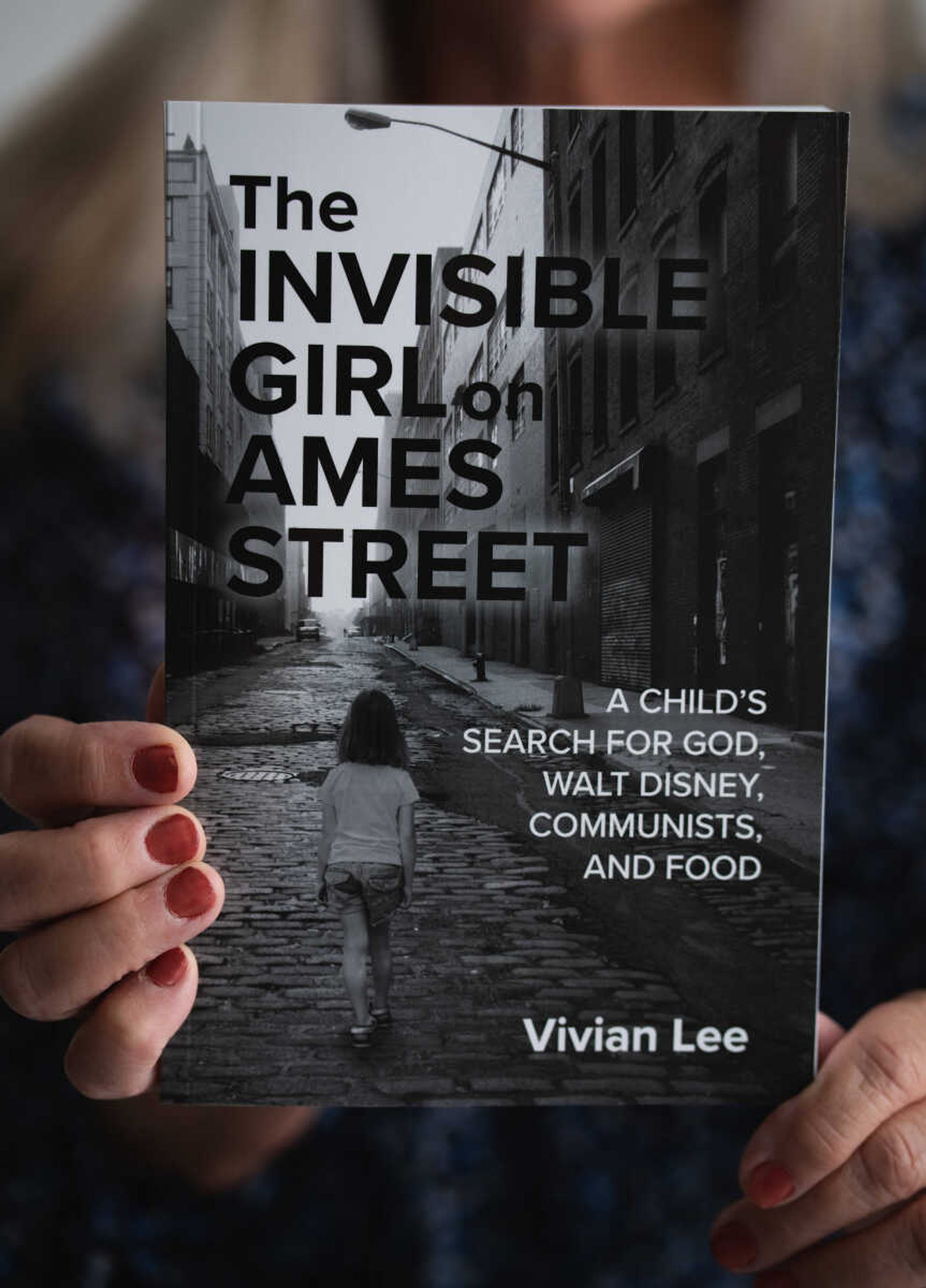 Vivian Selby holds up her book "The Invisible Girl on Ames Street." This book is available for purchase at Artistically Ever After in Cape Girardeau.