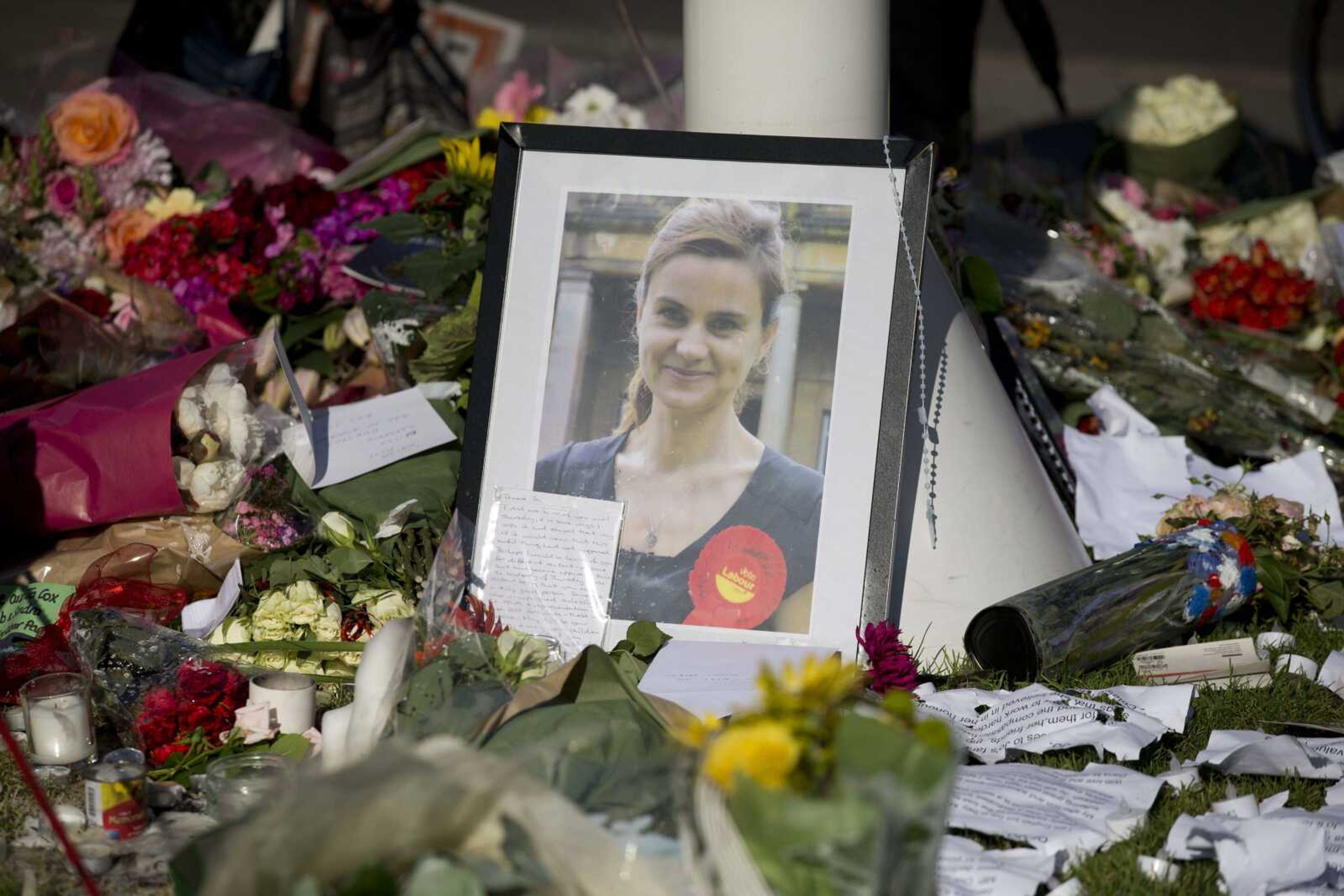 A photograph of Jo Cox, the 41-year-old member of Parliament fatally shot last week in northern England, stands among tributes laid in her memory in Parliament Square of London after a service of prayer and remembrance Monday to commemorate her.