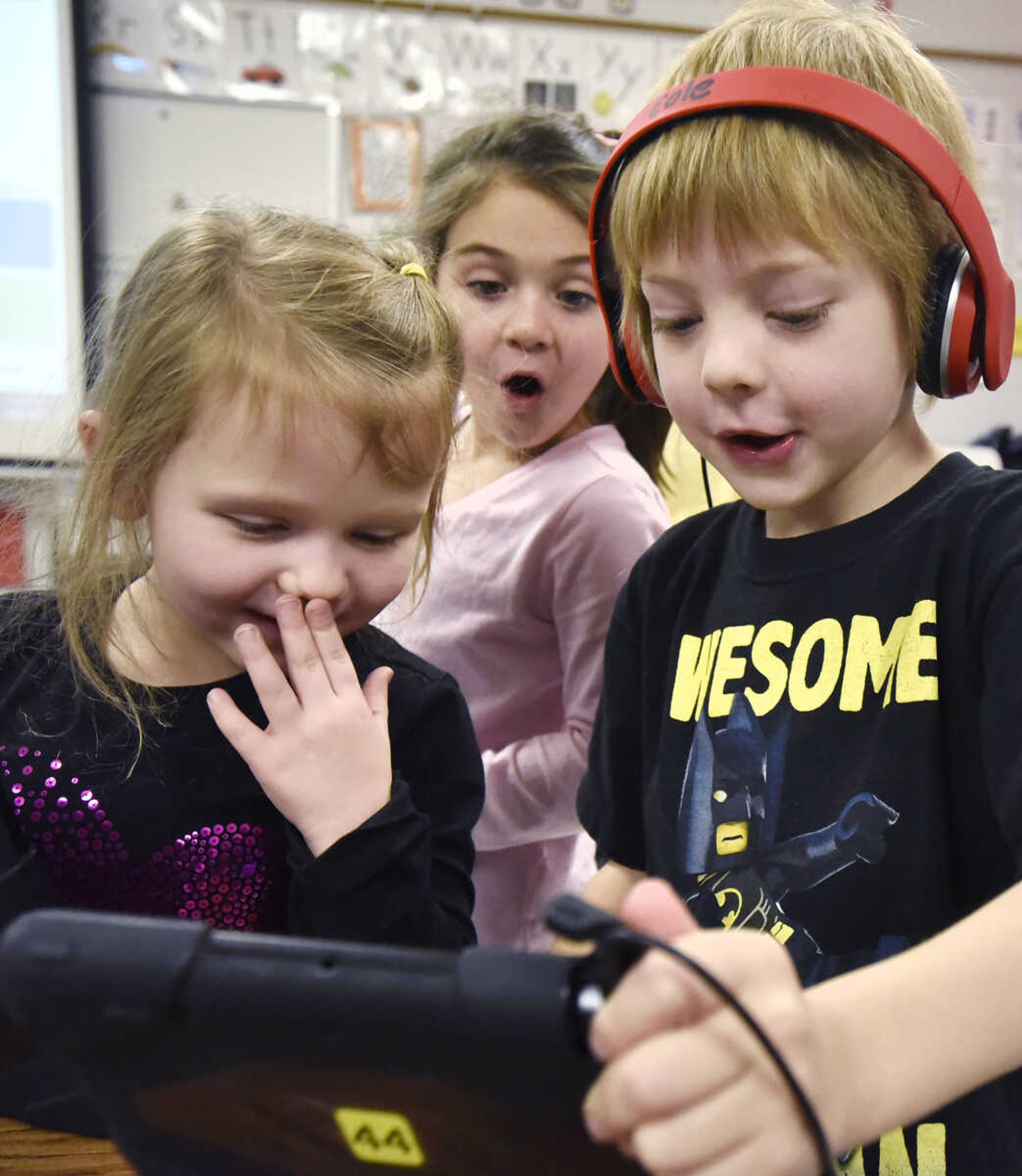 Presley Harrison, left, giggles as Addison Broussard, center, and Cole Kasten try out a photo app on an iPad on Friday, Jan. 6, 2016, in Jennie Pehle's kindergarten class at Orchard Drive Elementary in Jackson.