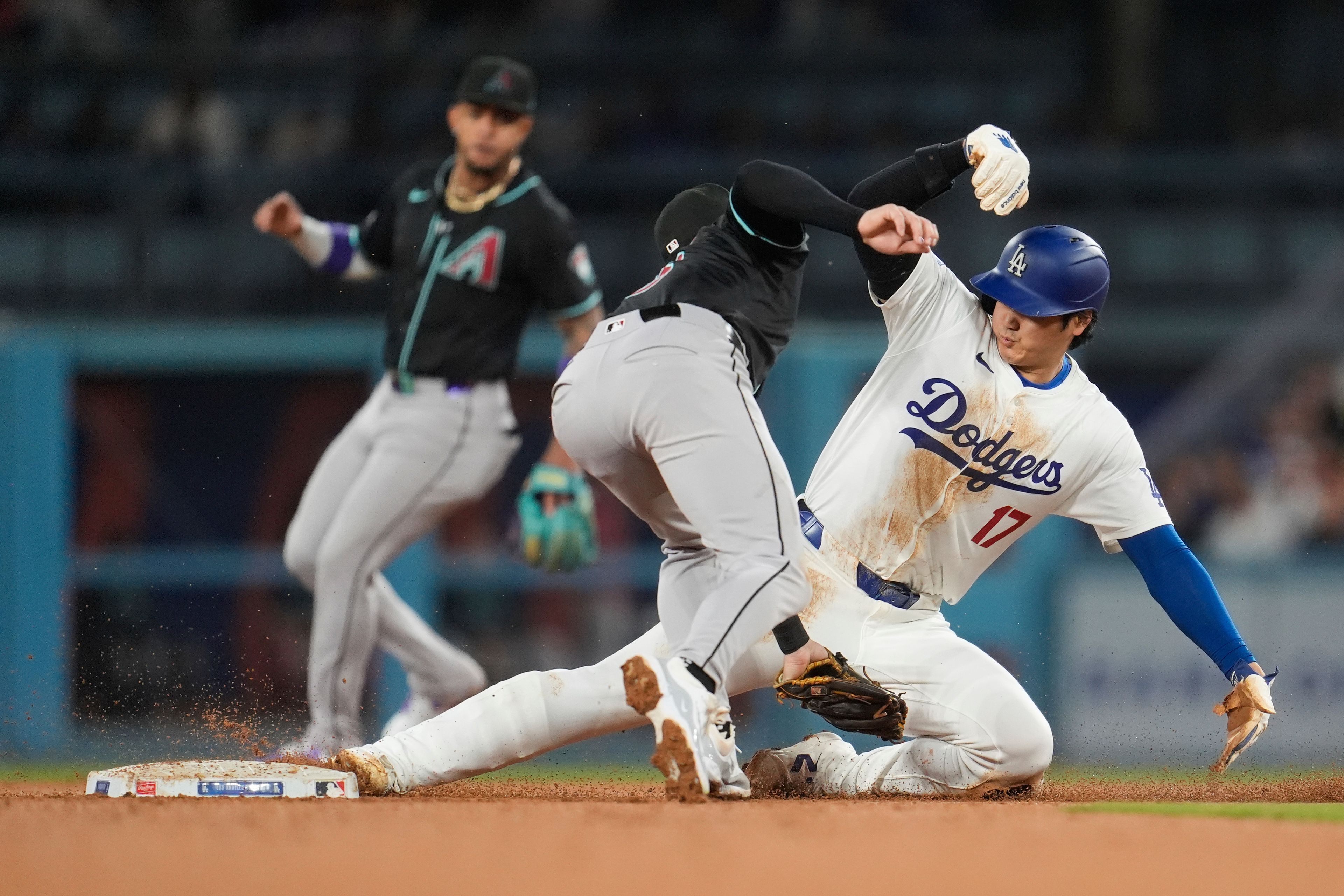 Los Angeles Dodgers' Shohei Ohtani, right, steals second base past Arizona Diamondbacks shortstop Kevin Newman during the sixth inning of a baseball game Tuesday, May 21, 2024, in Los Angeles. (AP Photo/Marcio Jose Sanchez)