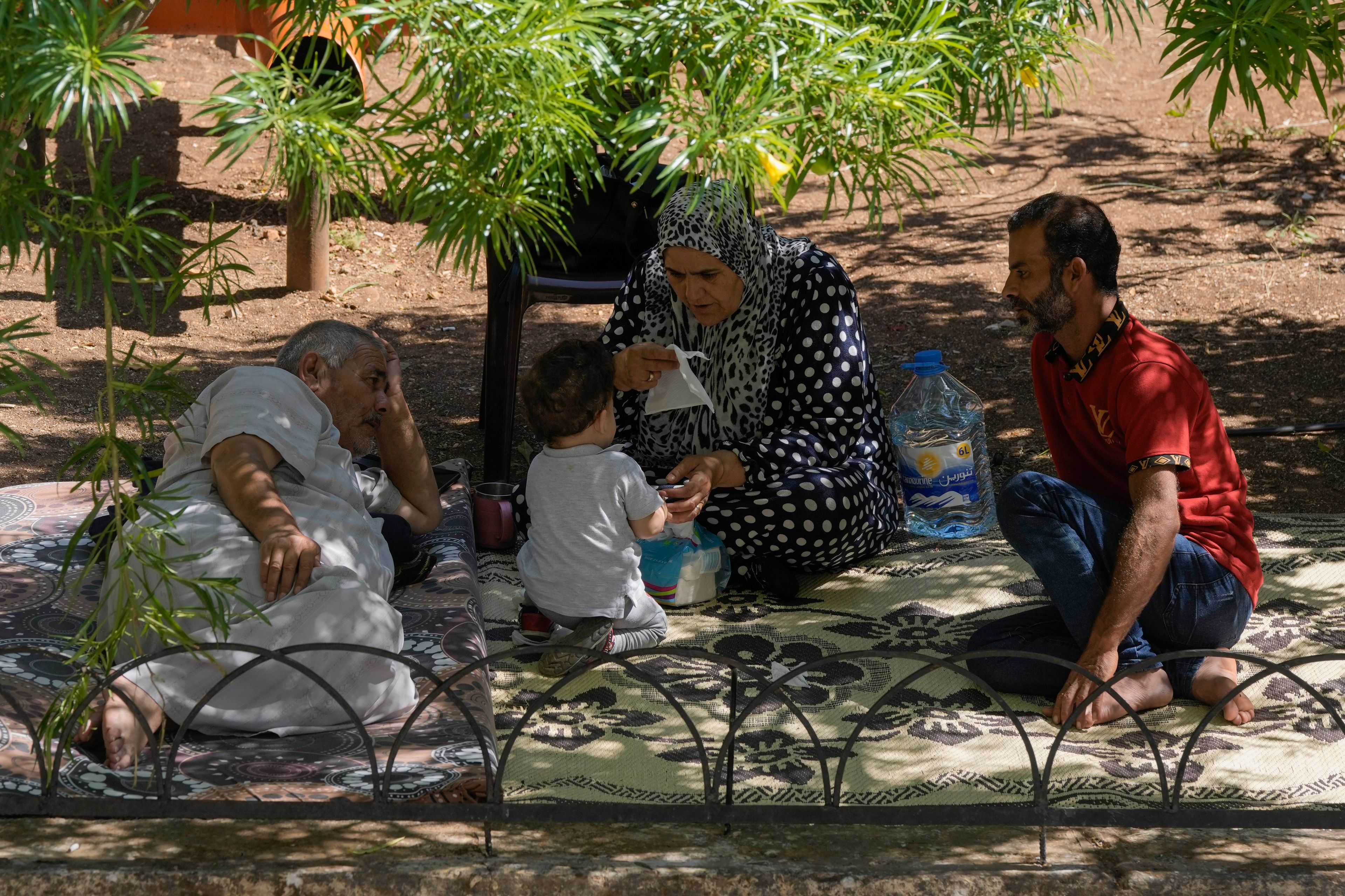 Displaced people sit at a vocational training center run by the U.N. agency for Palestinian refugees, or UNRWA, in the southern town of Sebline, south of Beirut, Lebanon, Friday, Oct. 4, 2024, after fleeing the Israeli airstrikes in the south. (AP Photo/Bilal Hussein)