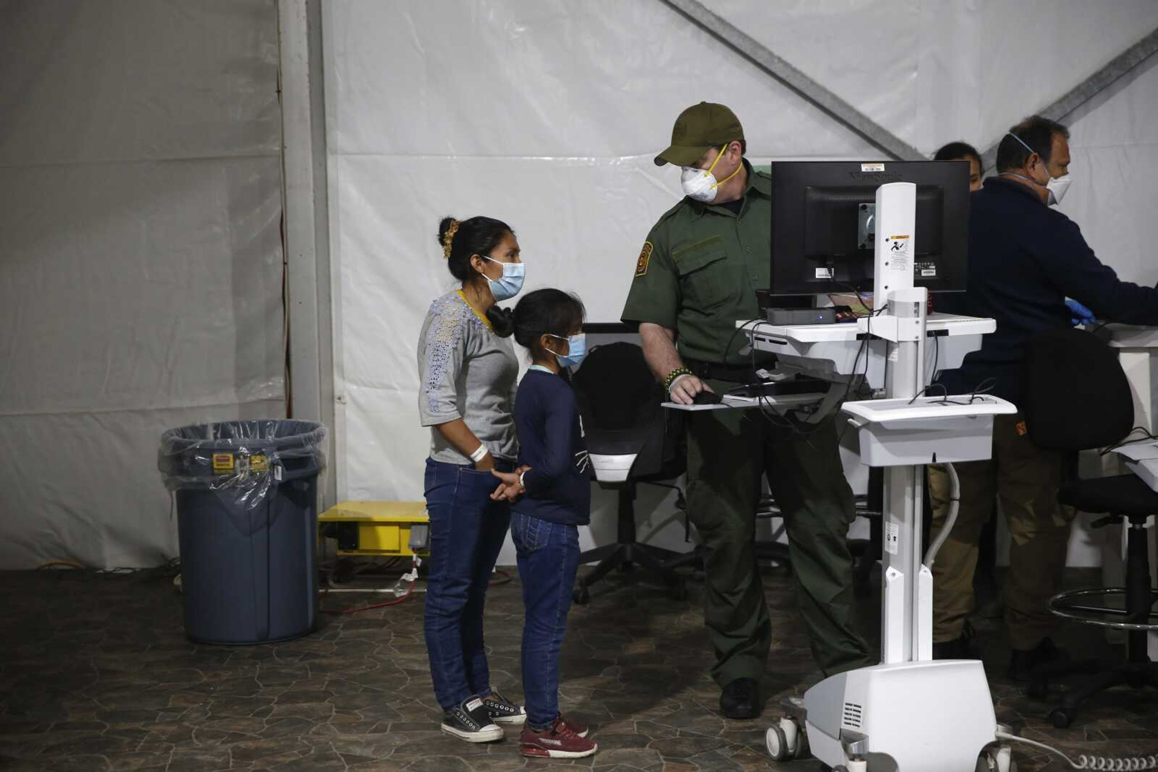 A migrant and her daughter have their biometric data entered at the intake area of the Donna Department of Homeland Security holding facility, the main detention center for unaccompanied children in the Rio Grande Valley, Tuesday in Donna, Texas.