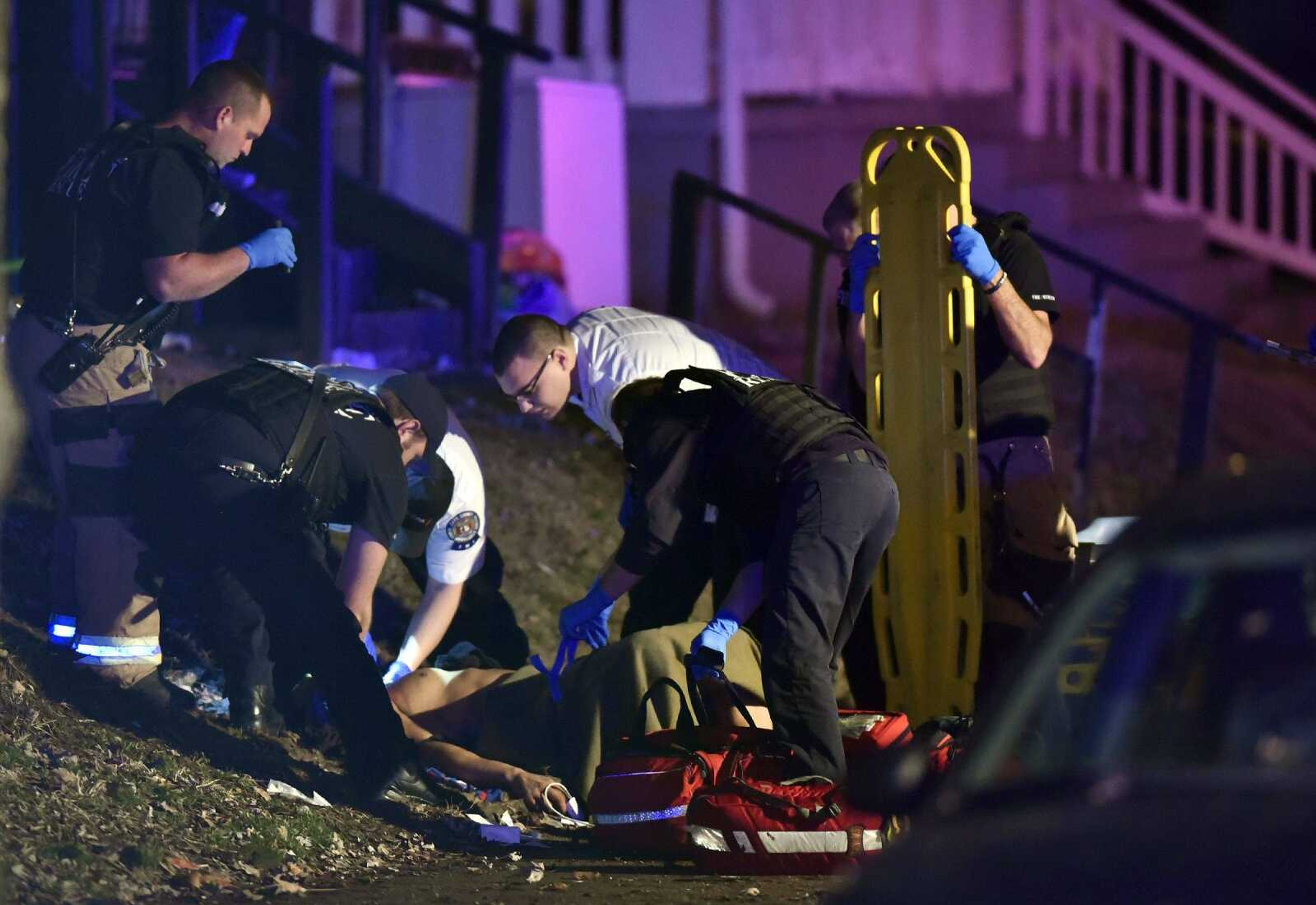 Paramedics and EMTs with the Cape Girardeau Fire Department and Cape County Private Ambulance work on a victim after a shooting on the 1000 block of Jefferson Avenue on Wednesday evening.