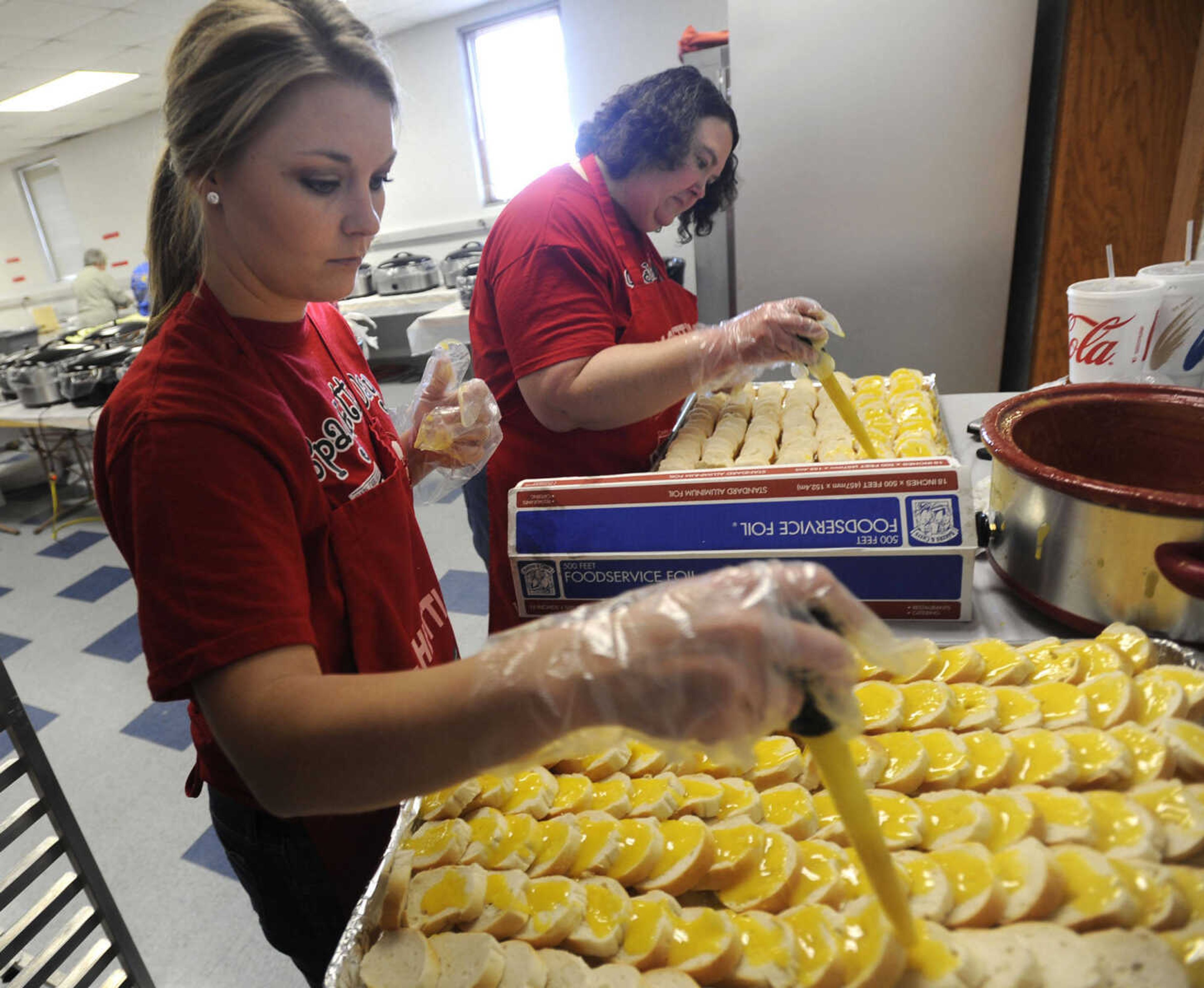 Stacy Welter, left, and Diane Boyer add garlic butter to bread for the Parks & Recreation Foundation Spaghetti Day Wednesday, Nov. 13, 2013 at the Arena Building.