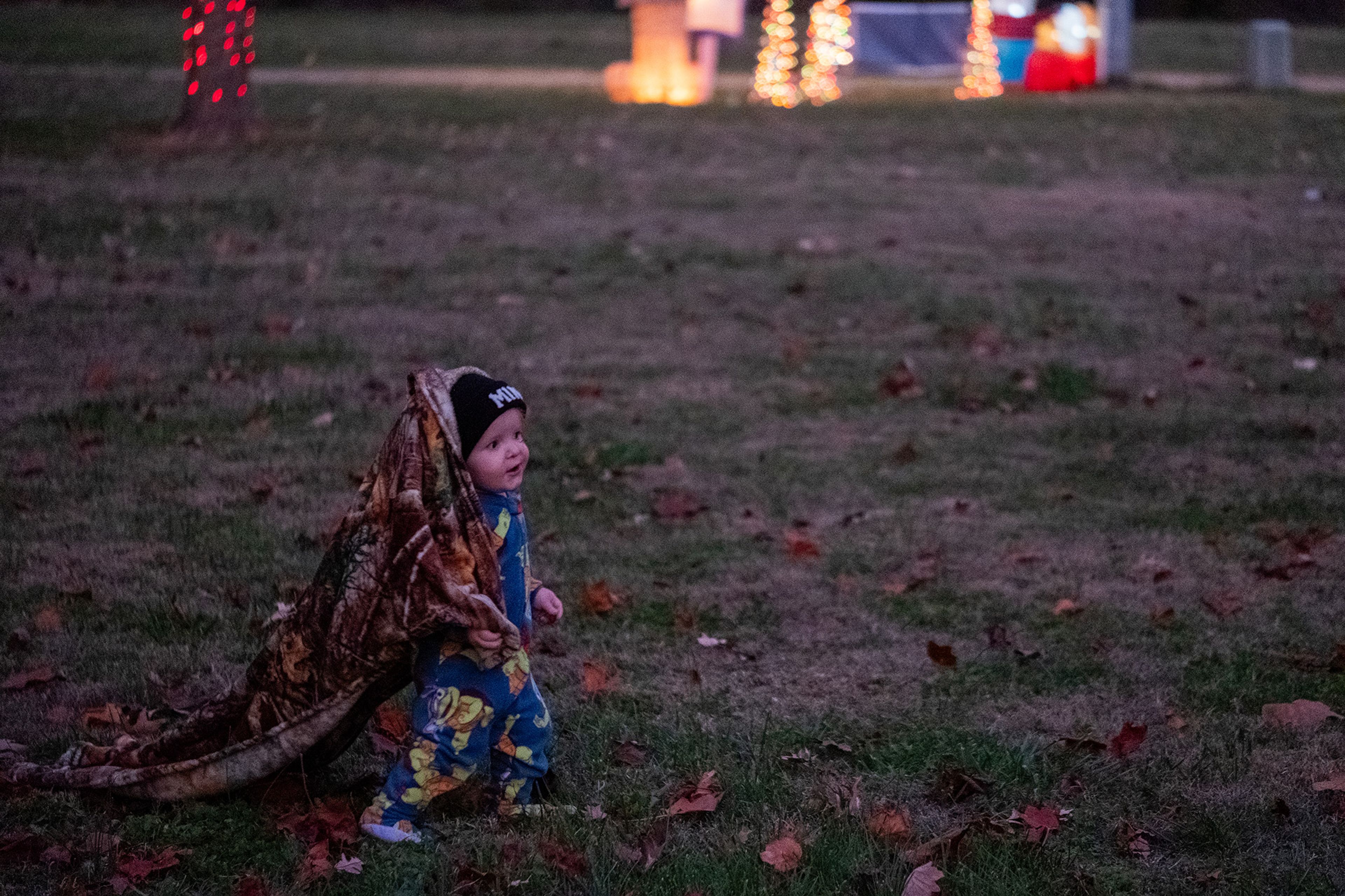 Children play on the grass while waiting for the tree-lighting ceremony to begin.
