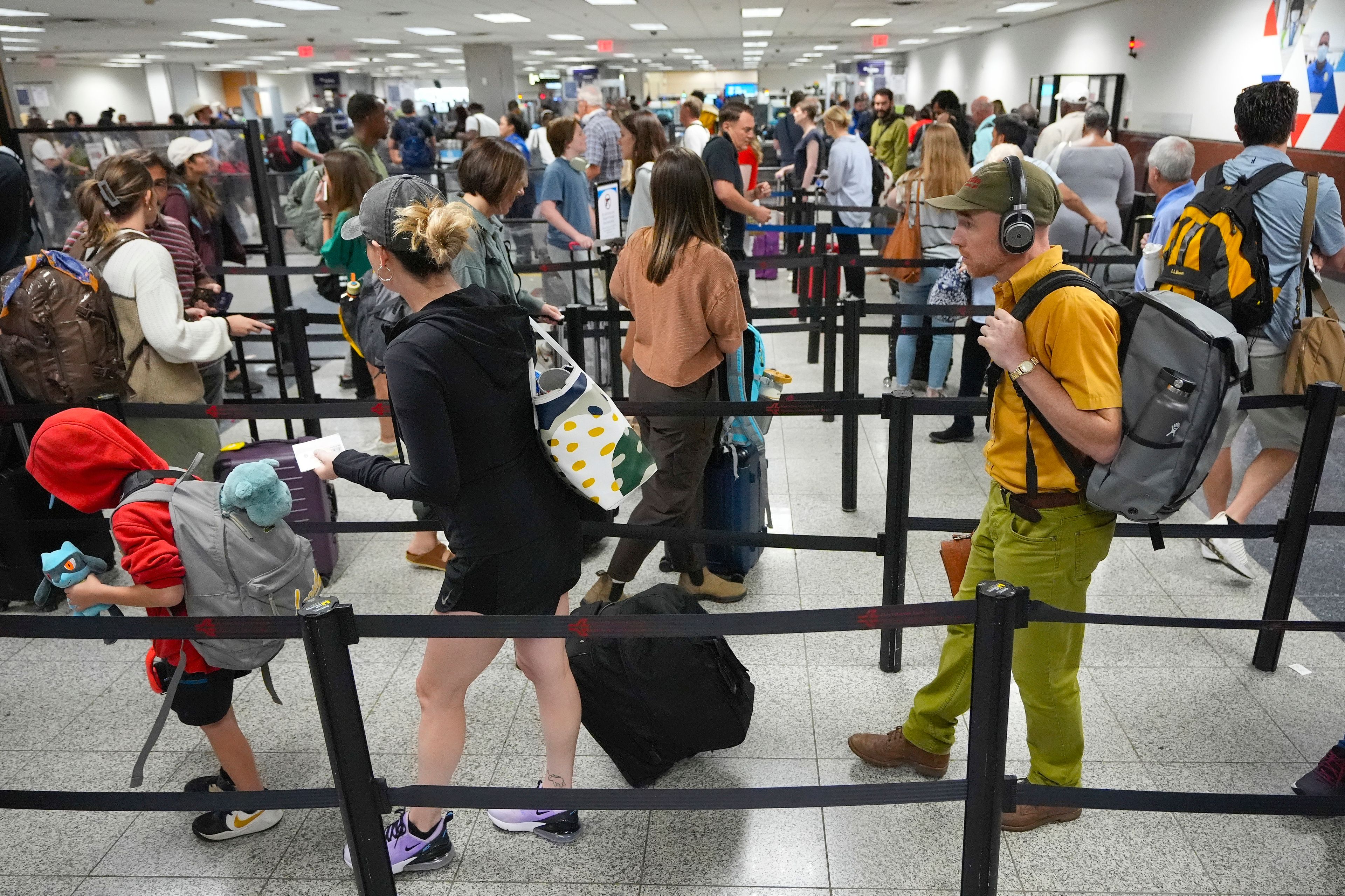 FILE - Travelers line up for security clearance at Hartsfield-Jackson Atlanta International Airport on June 28, 2024, in Atlanta. (AP Photo/Pablo Martinez Monsivais, File)